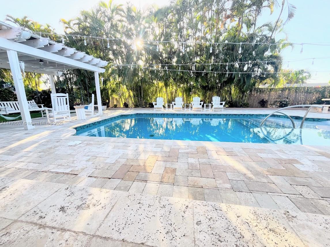 Move-In Ready! This exquisitely remodeled 4-bed, 2-bath pool home blends elegance with comfort. Features include impact windows and doors, a gourmet kitchen with all-wood cabinetry, stainless appliances, and a spacious pantry. Custom closets, plantation shutters, crema marfil marble, and high-end porcelain floors add timeless charm. Enjoy a sleek electric fireplace, new tankless water heater, and two A/C systems. The oversized 2-car garage offers extensive built-ins, plus a separate shed. Outside, relax in your private oasis with a heated pool, sun-shelf, and travertine pavers. Community tennis and pickle ball courts, park and very close to highway and Marina! Simply move in and enjoy!