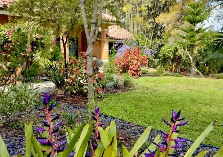 Own one of 49 exclusive custom homes in Westwoods — set on 1+ acre with tranquil lake views, surrounded by award-winning botanical gardens and rare tropical plants. As you enter this tropical estate, soaring cathedral ceilings flood the space with natural light. The open gourmet kitchen stuns with Maple Cabinetry, Labradorite countertops and backsplash. The floors provide a blend of natural elements: Brazilian Pecan in primary en-suite and guest room, Teak in bedrooms, and Bisque Saltillo throughout. Enjoy unmatched privacy, lake views, and low-key HOA, complete with dual-zone A/C, 2-car garage and workshop. Close to top-rated schools, hospitals, shopping, dining, and a short drive to PBI Airport, world-class beaches and Palm Beach Polo Club. Privacy. Prestige. Palm Beach at its finest.