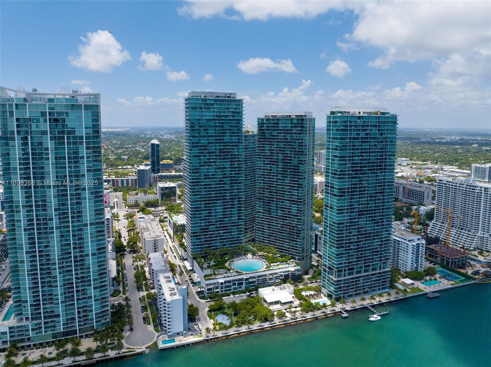 Panoramic Views at Paraiso Bay! Immaculate 1 bed / 1.5 bath with breathtaking direct water views. Move-in ready with updated porcelain floors, custom built-in cabinetry in the bedroom, Bosch appliances, high-end finishes, built-out closets, and blackout shades. Furniture is negotiable and in excellent condition. Enjoy resort-style amenities: world-class gym, spa, wine cellar, cigar lounge, theater, home cinema, bowling alley, two tennis courts, and a massive circular pool. Private gated community in Edgewater—minutes to Design District, Wynwood, Brickell, beaches, and top dining.