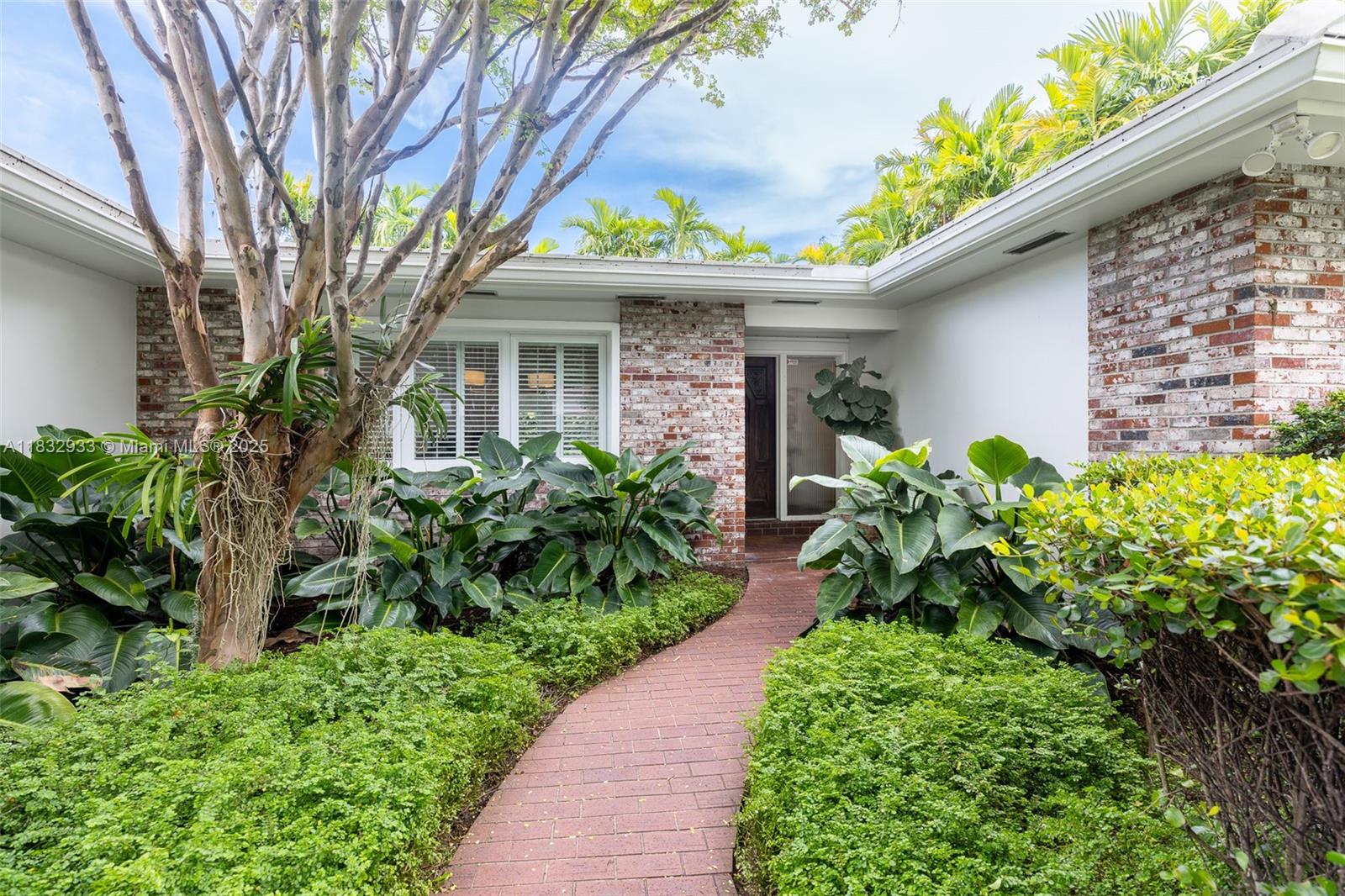 Located in coveted South Gables on a tree-lined street, this elegant 2,280 sq ft residence blends traditional elements with modern upgrades. Set on a manicured lot with lush landscaping, it features a charming brick path entry, a serene backyard with wood deck and additional areas with premium artificial turf. A bright Florida room seamlessly connects the indoors with the outdoors, while interiors showcase soaring ceilings, crown moldings, hardwood floors, and impact windows. The custom kitchen boasts quartz countertops, tile backsplash, and top-tier appliances. The spacious primary suite offers dual closets and a refined bath with frameless glass shower. A 1-car garage with storm-grade door completes this turn-key gem.