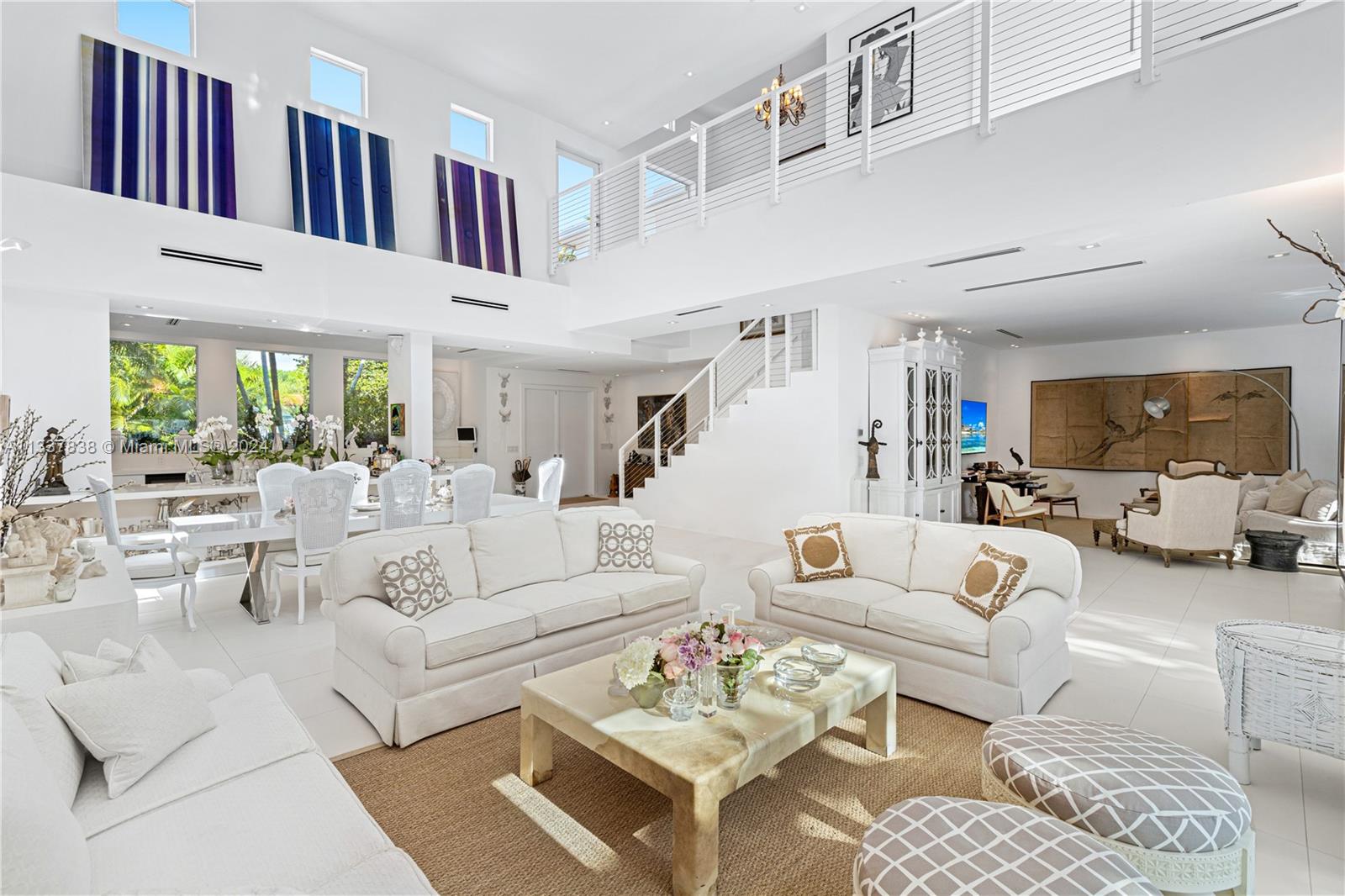 ENJOY THE PEACEFUL AESTHETIC OF THIS TREE-LINED KEY BISCAYNE MiMo STYLE FAMILY ESTATE WITH SOARING 25 FT CEILINGS ON OVERSIZED CORNER LOT! 4,021 SF Home Nestled in Nature w/ 5 Bedrooms + 4.5 Baths on Large 8,000 SF LOT. Light & Bright Grand OPEN Livingroom Boasts Double Height Ceilings w/ Recessed Lighting & Lineal AC Diffusers. Family Room & Dining Area flow into the Modern Eat-in Chef’s Kitchen in White featuring an Oversized Island, Miele Stainless Steel Appliances & Wine Refrigerator w/ Windows overlooking Lush Greenery. White Staircase Leads to Large Primary Suite w/ 2 Walk-in Closets + 2 Terraces. Primary Bath Wrapped in White w/ Floating Tub & Steam Rainshower. Outdoor Entertaining & Lounging Areas sit on White Wood Deck. Pool wrapped by Manicured Gardens for the Utmost of Privacy.