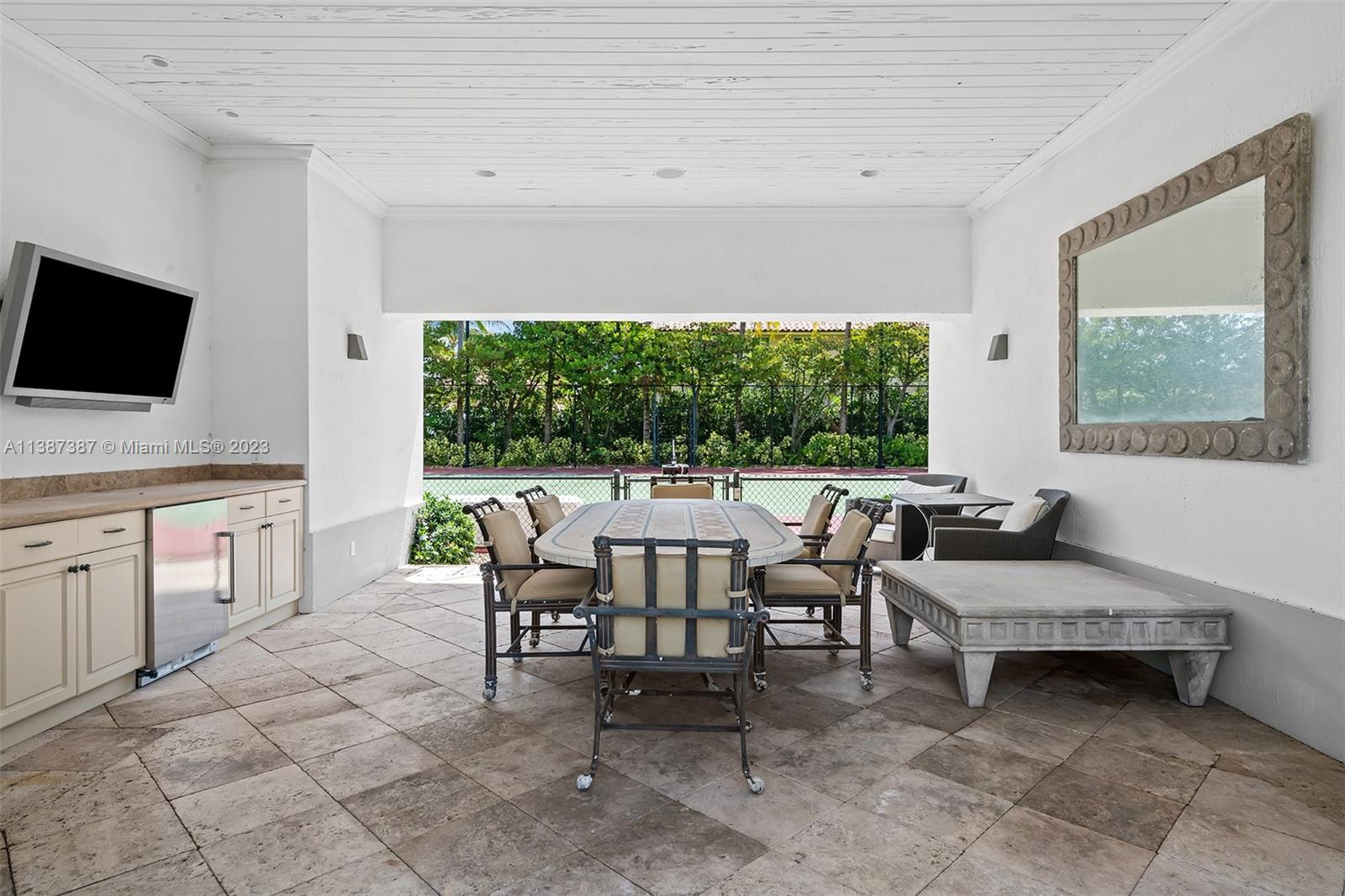 Tennis cabana with seating area and storage cabinets and TV.