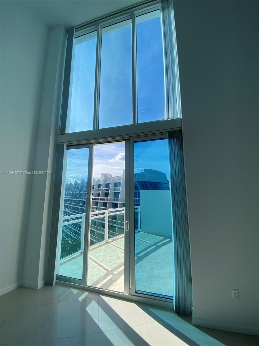 Floor to ceiling windows leading out to balcony.