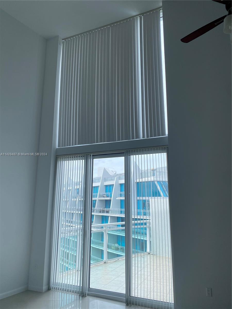 Floor to ceiling windows leading out to balcony.