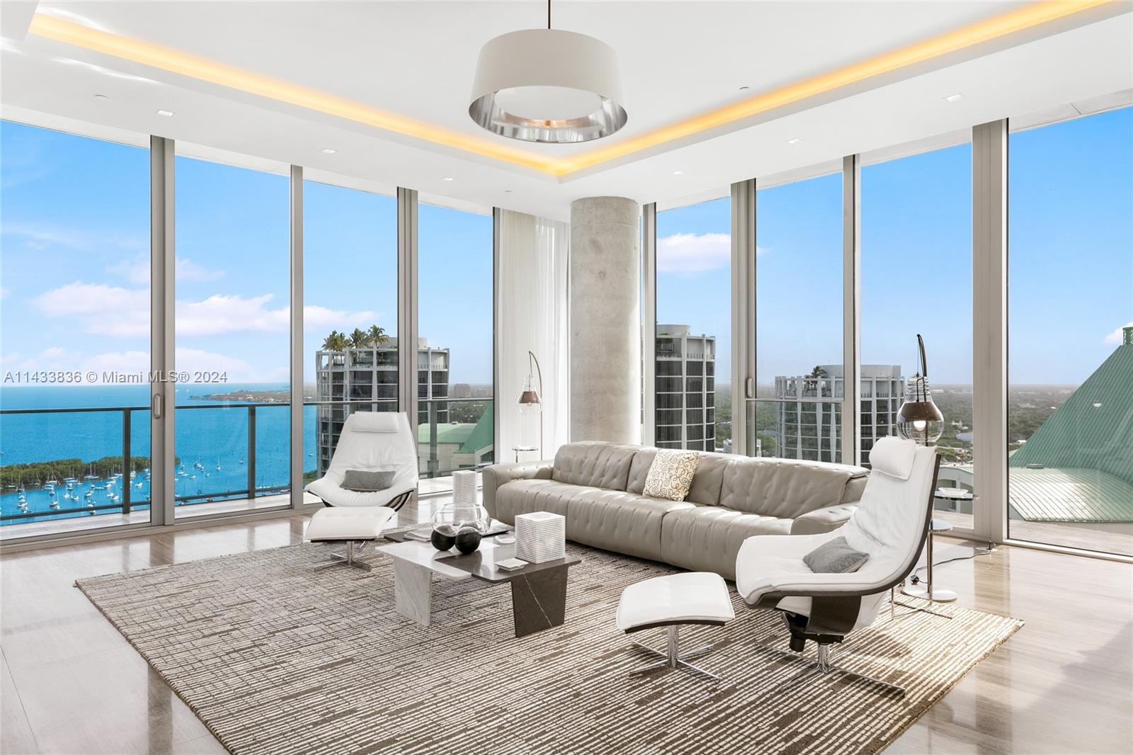 Discover Miami's grandest single-floor condo in Miami, spanning 11,000 sq. ft with 12' ceilings. This penthouse, designed by Nick Luaces, showcases 6 beds, 6 baths, 2 powder rooms, a theater, library, office, and distinct seating zones. Boasting Bang & Olufsen home automation, the 3,000 sq. ft master suite stuns with a chic dressing area, midnight kitchen, gym, sauna, and terraces accessible from public spaces. This home includes access to a 4-car private garage with storage. Enjoy bay views from the unique wrap-around terrace, private elevator foyer, and deluxe kitchen.  This masterpiece resides in Grove at Grand Bay by architect Bjarke Engels. Experience an unparalleled lifestyle living in the heart of the Grove!