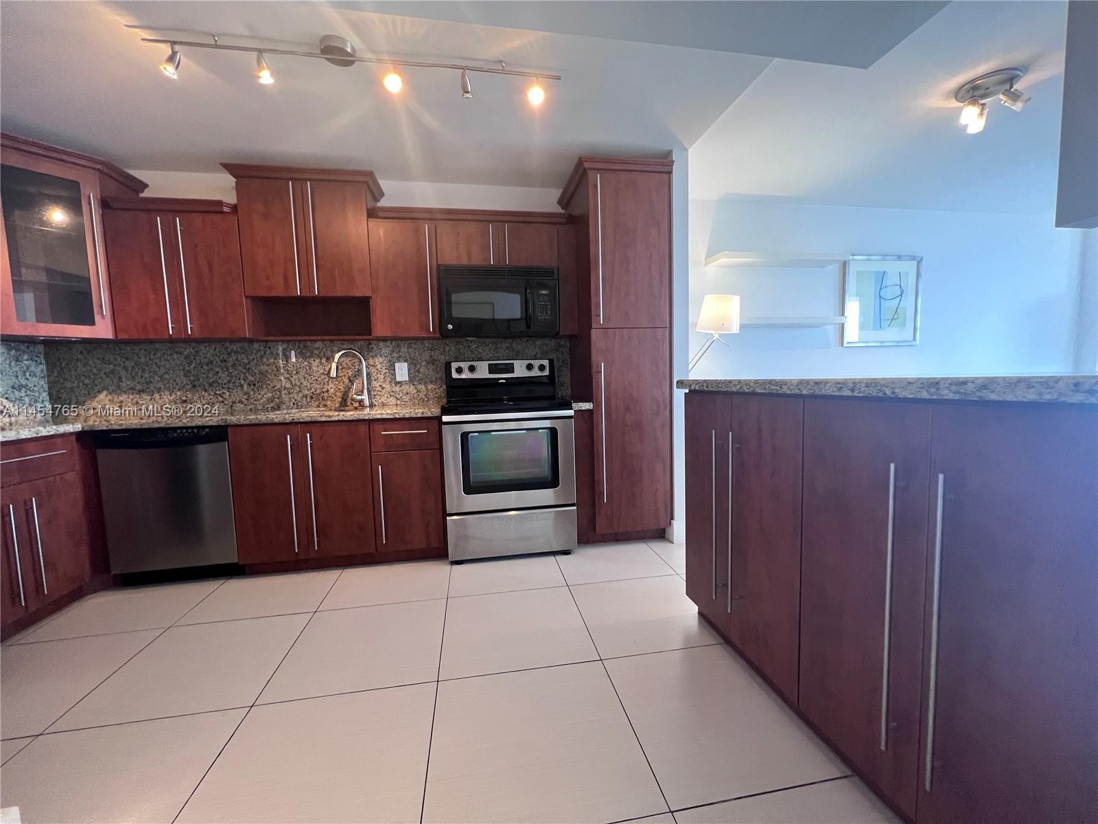 Beautiful kitchen with Lots of cabinets and snack bar.