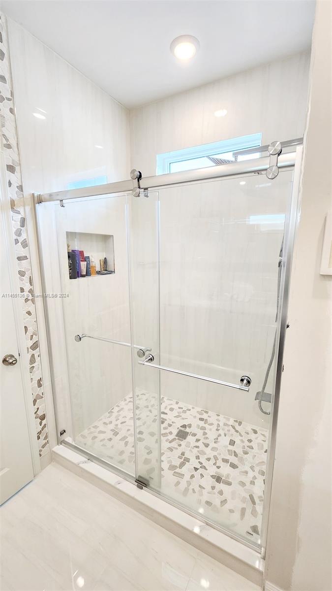 The remodeled master bathroom is a true oasis, featuring upgraded shower fixtures, exquisite tile work, and elegant walls, creating a spa-like atmosphere.