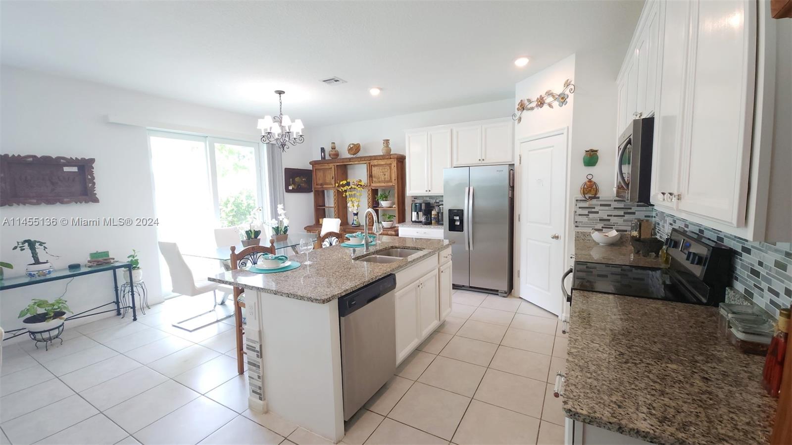 The open-concept kitchen is a chef's dream, featuring upgraded backsplash tiles, a modern faucet, and upgraded lighting fixtures.