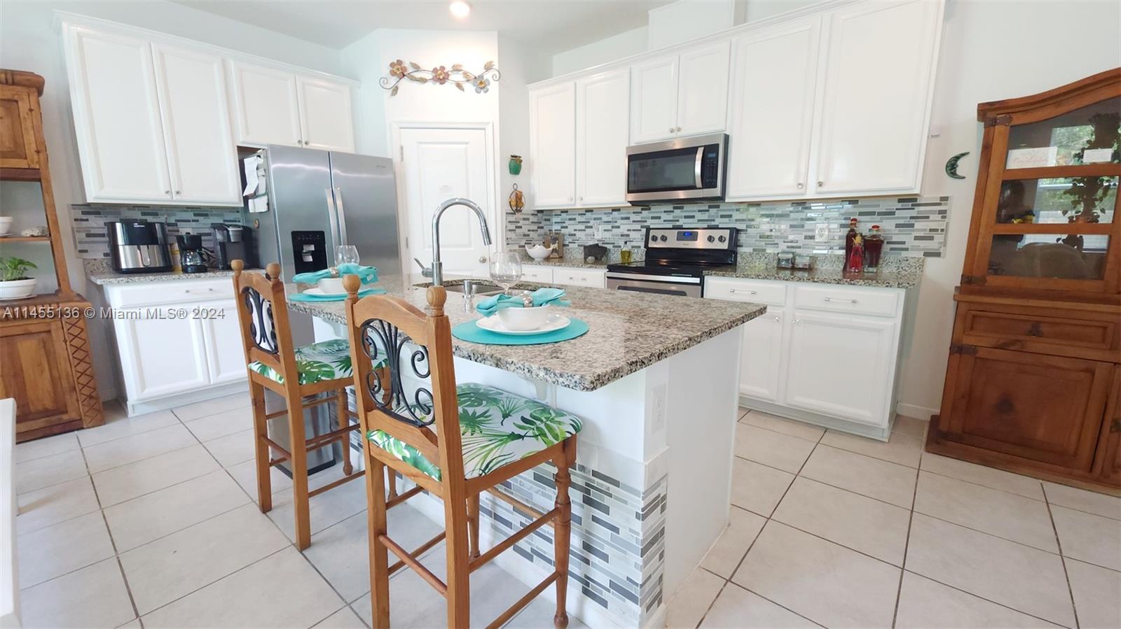 The open-concept kitchen is a chef's dream, featuring upgraded backsplash tiles, a modern faucet, and upgraded lighting fixtures.