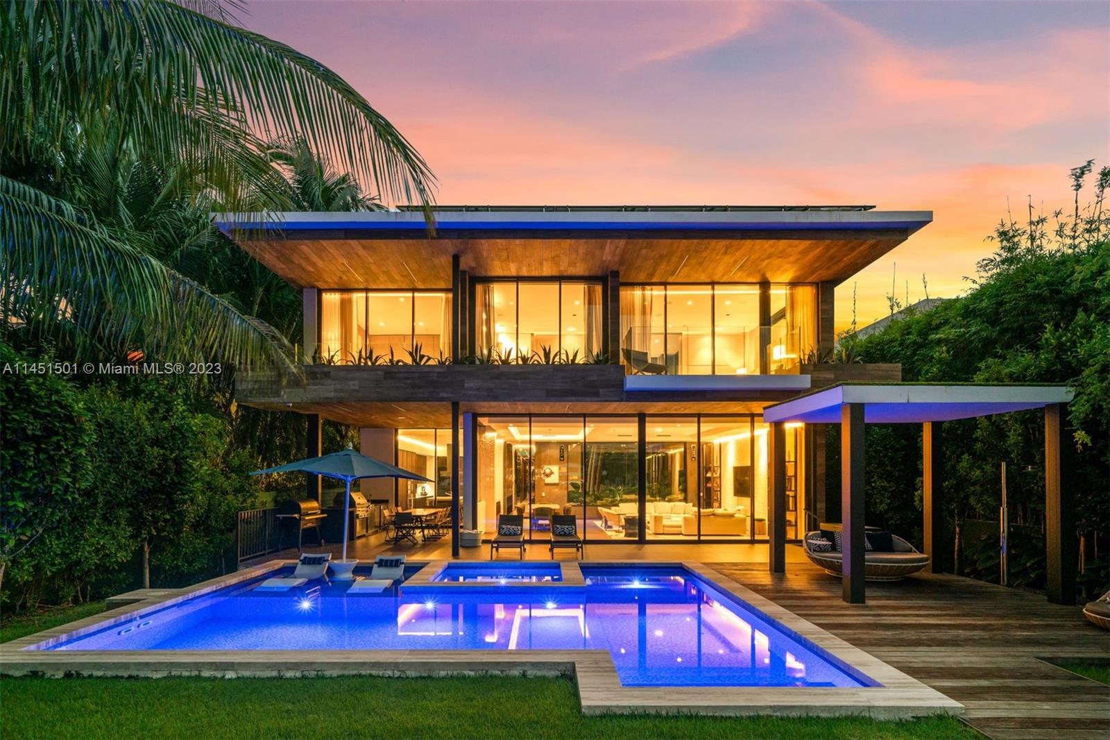Embrace a modern, tropical lifestyle on the Venetian Islands in this elegant, solar-powered home designed by Max Strang featuring exquisite interiors by Studio ABM Design. Encapsulating over 10,500 sq ft with 60 ft of waterfront, this architectural gem seamlessly integrates indoor and outdoor spaces for the premier island living experience. Expertly weaving wood, stone, and glass finishes throughout, this home exudes entertaining possibilities with a roof deck with eastern sunrise and downtown sunset panoramic views, home theater, multiple balconies, and a kitchen equipped with Wolf gas and induction stovetops, twin Sub-zero refrigerators, and built-in wine cooler. Relax by the mosaic-tiled pool, surrounded by the lush landscape and Ipe wood deck with outdoor chef’s kitchen and boat lift.