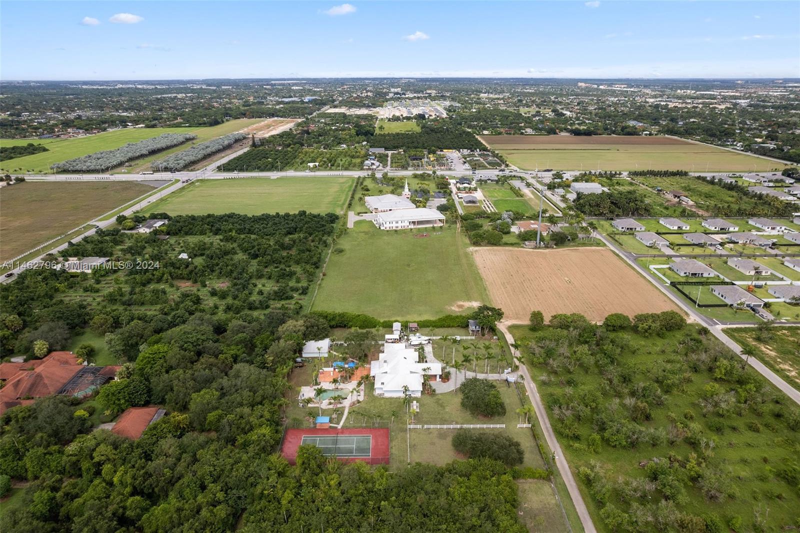 Aerial View showing full tennis court, heated pool, stables/barn, fully fenced property, generator.  Private entrance.