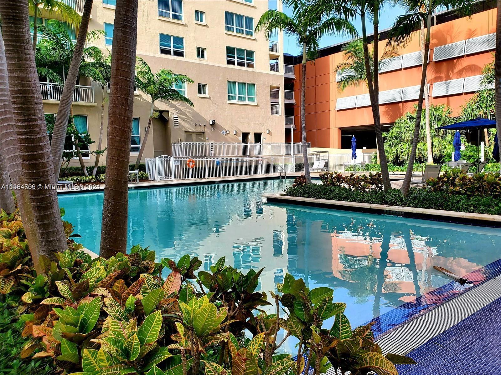 Resort-style pool surrounded by palm trees.