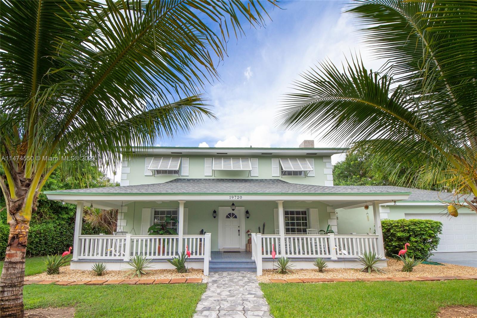 Charming Key-West style Redland estate home with an inviting front porch. This lovingly restored gem seamlessly blends timeless character with modern updates. The two-story main house boasts 4 bedrooms and 2.5 bathrooms, offering generous downstairs living spaces, a cozy fireplace, a spacious screened back terrace, and the convenience of an attached 2-car garage. The property features a 1 bed/1bath In-Laws Quarters at ground level with private entry and a large living area for extended living options. Recent renovations include a new roof, a top-notch water filtration/conditioning system, and the legalization and successful inspection of all structures by the county. The property spans from block to block and showcases a variety of fruit trees.