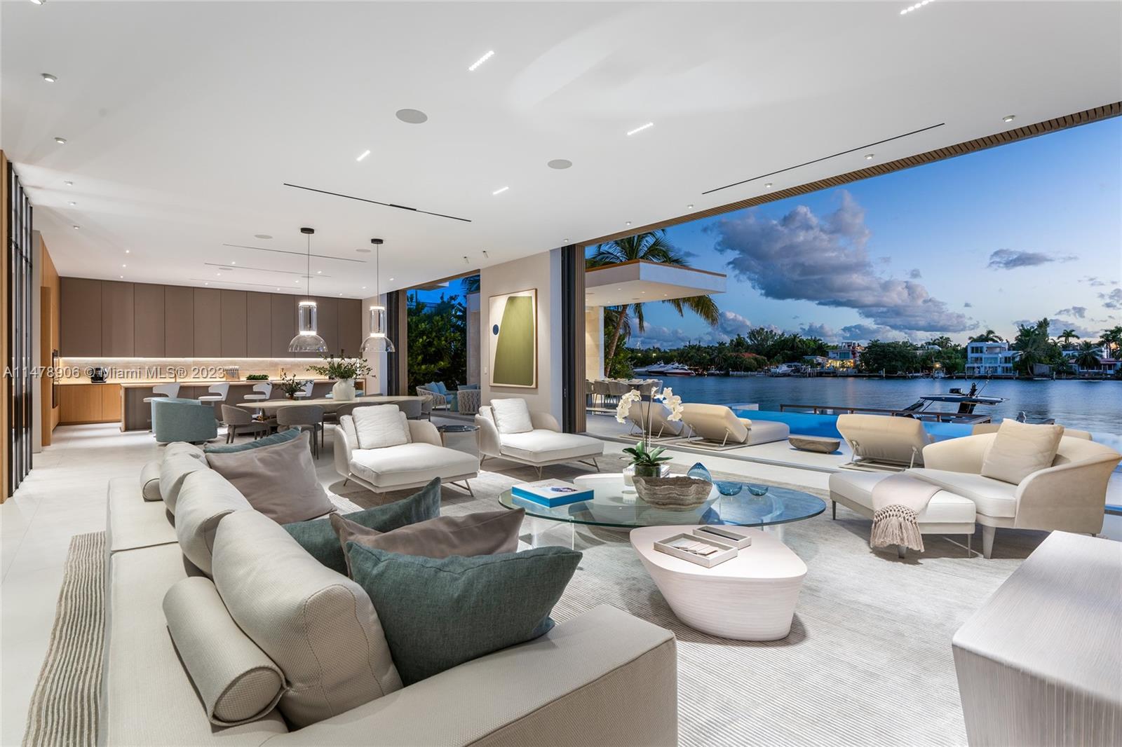 This 2-story, Ralph Choeff designed waterfront estate on guard-gated Hibiscus Island truly epitomizes luxury living in Miami Beach. Property boasts 7BR/7+1BA, sitting on a meticulously landscaped 15,750 SF lot, w/panoramic vistas of the iconic Miami skyline. Inside, the residence showcases impeccable interior design, soaring ceilings, & floor-to-ceiling telescoping glass doors that flood serene natural light while bringing the outdoors in. The expansive Great Room seamlessly integrates a family/media room, dining area, & chef's kitchen, all w/captivating water views. The 2nd story principal suite offers a terrace overlooking the waterway with city views and a beautiful plunge pool/spa. Outdoor spaces are a tropical oasis w/infinity pool, private dock for large vessels & easy ocean access.