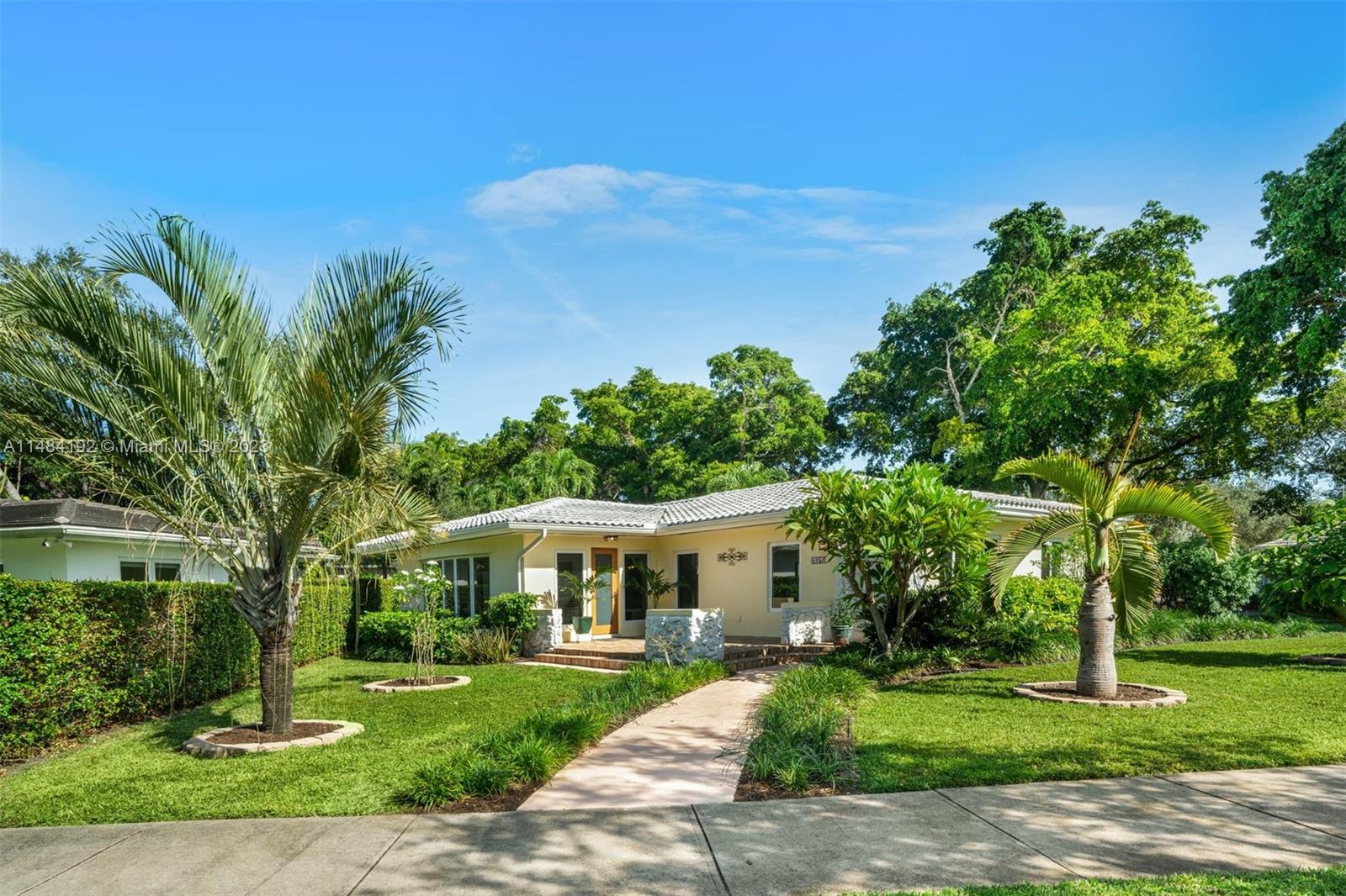 Charming 3-bed 2-bath home on a 10,000 sq ft corner lot in the heart of Coral Gables. Natural light bathes hardwood floors in the main living areas, and wooden millwork accents extend to the kitchen and bedrooms with tongue and groove ceilings. The light and airy kitchen comes with a double oven and Corian countertops. The bathrooms were remodeled in 2016; impact windows and doors and a new storm door for the 2-car garage were installed in 2017; and in 2023 a new air conditioning unit and septic tank were put in. Mature landscaping and a Calusa privacy-hedge borders the generously sized backyard, with room for plantings around existing fruit trees, or installing a deck or pool for entertaining. Within minutes of a Metrorail Station, Coral Gables Youth Center, Merrick Park and Miracle Mile.