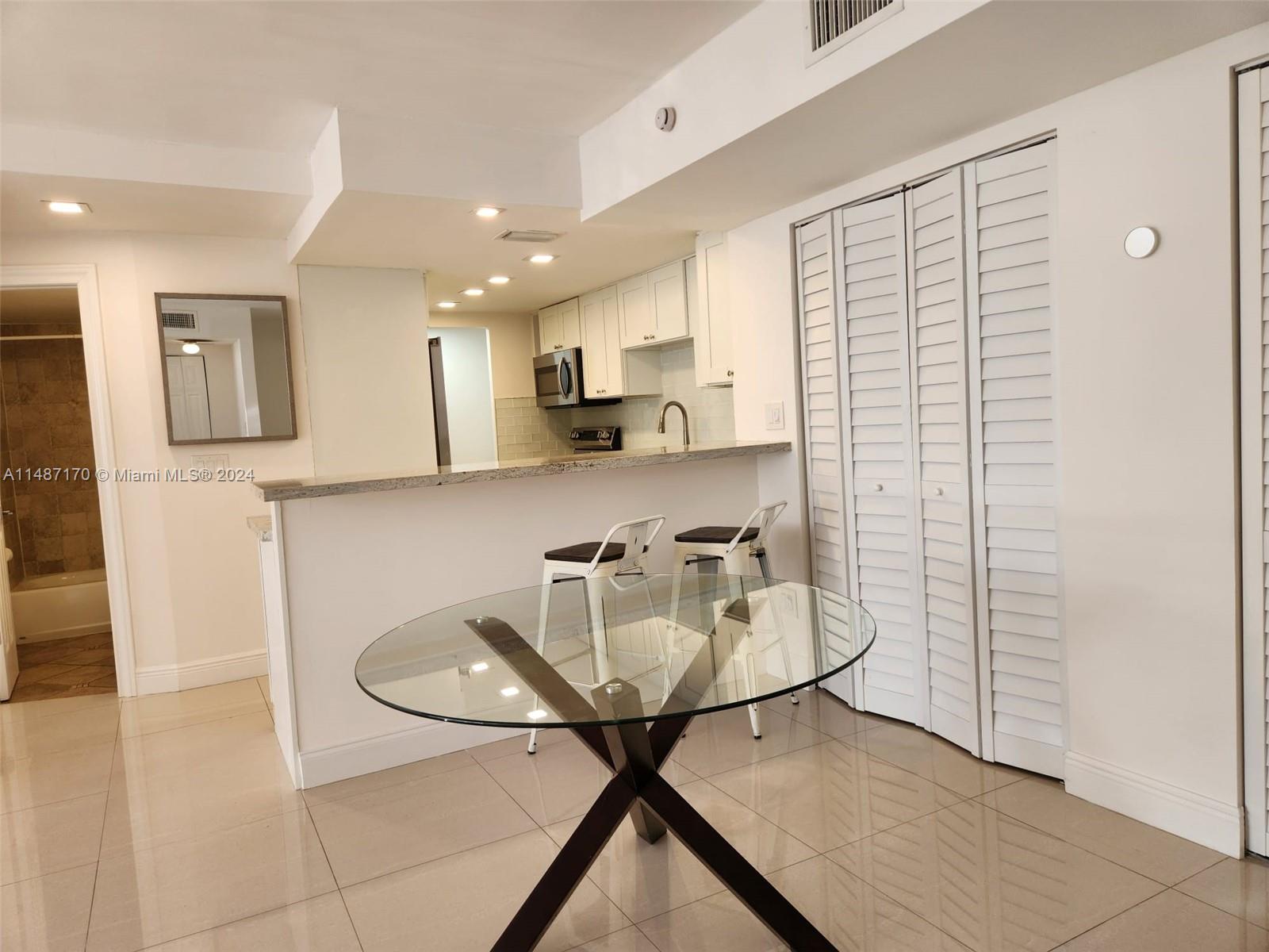 This view shows dining area with kitchen bar and additional closet for either storage space or convert to a wine/coffee bar.