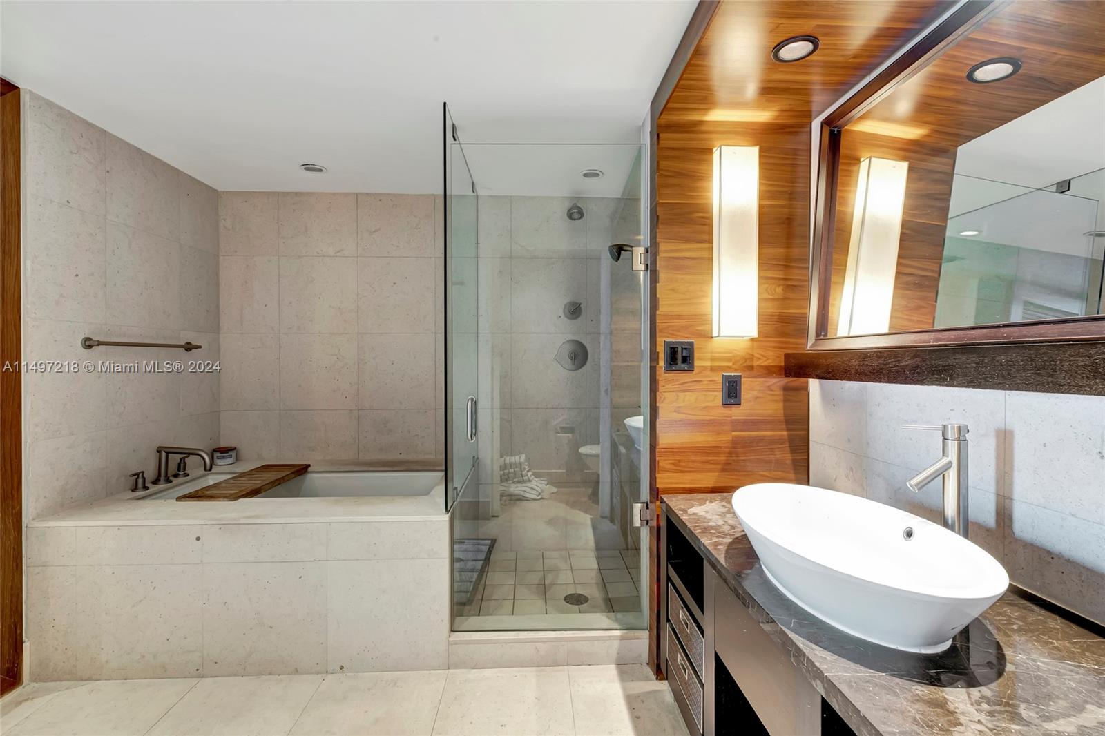 Spacious Bedroom with ensuite 4-piece bath/spa is designed in warm wood tones, natural stone and glass with private WC.