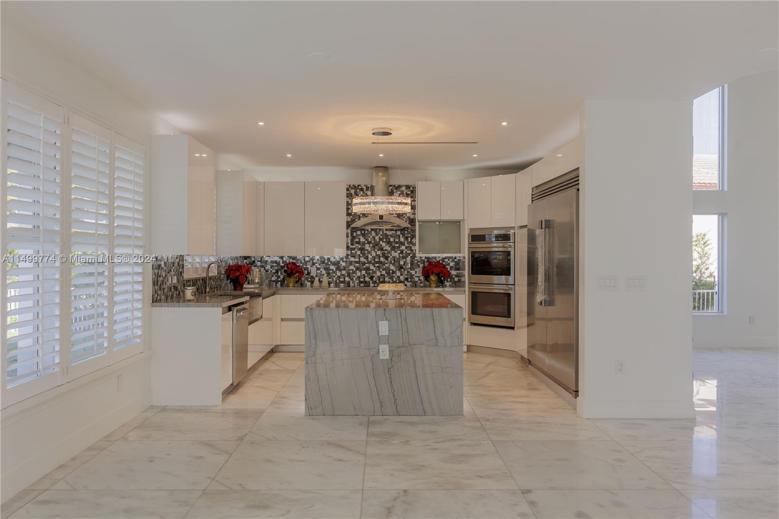 The marble countertops are a standout feature in this kitchen. These countertops not only add an element of elegance but also provide durability and ease of maintenance. The marble surface offers a spacious and sturdy workspace for food preparation.