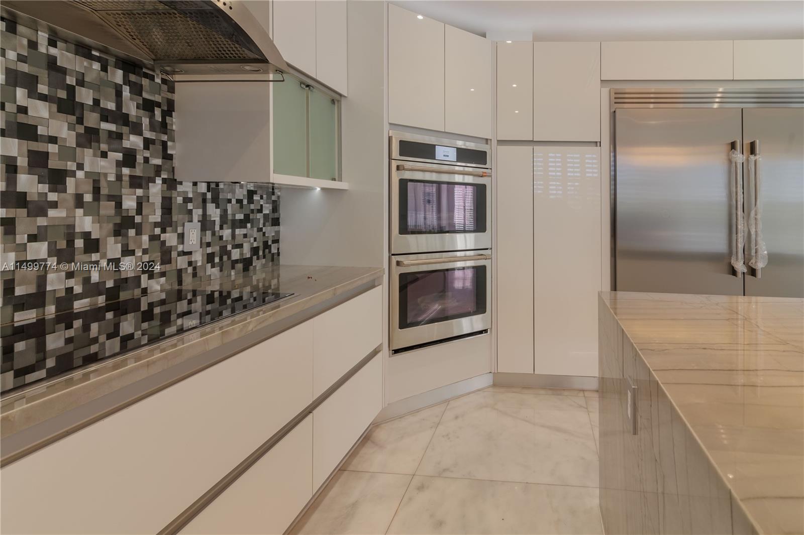 The high-end stainless steel appliances are a chef's dream. The range offers precision cooking, the oven ensures even baking, and the refrigerator provides ample storage for fresh ingredients. The seamless integration of these appliances adds to the kitchen's modern and sleek aesthetic.