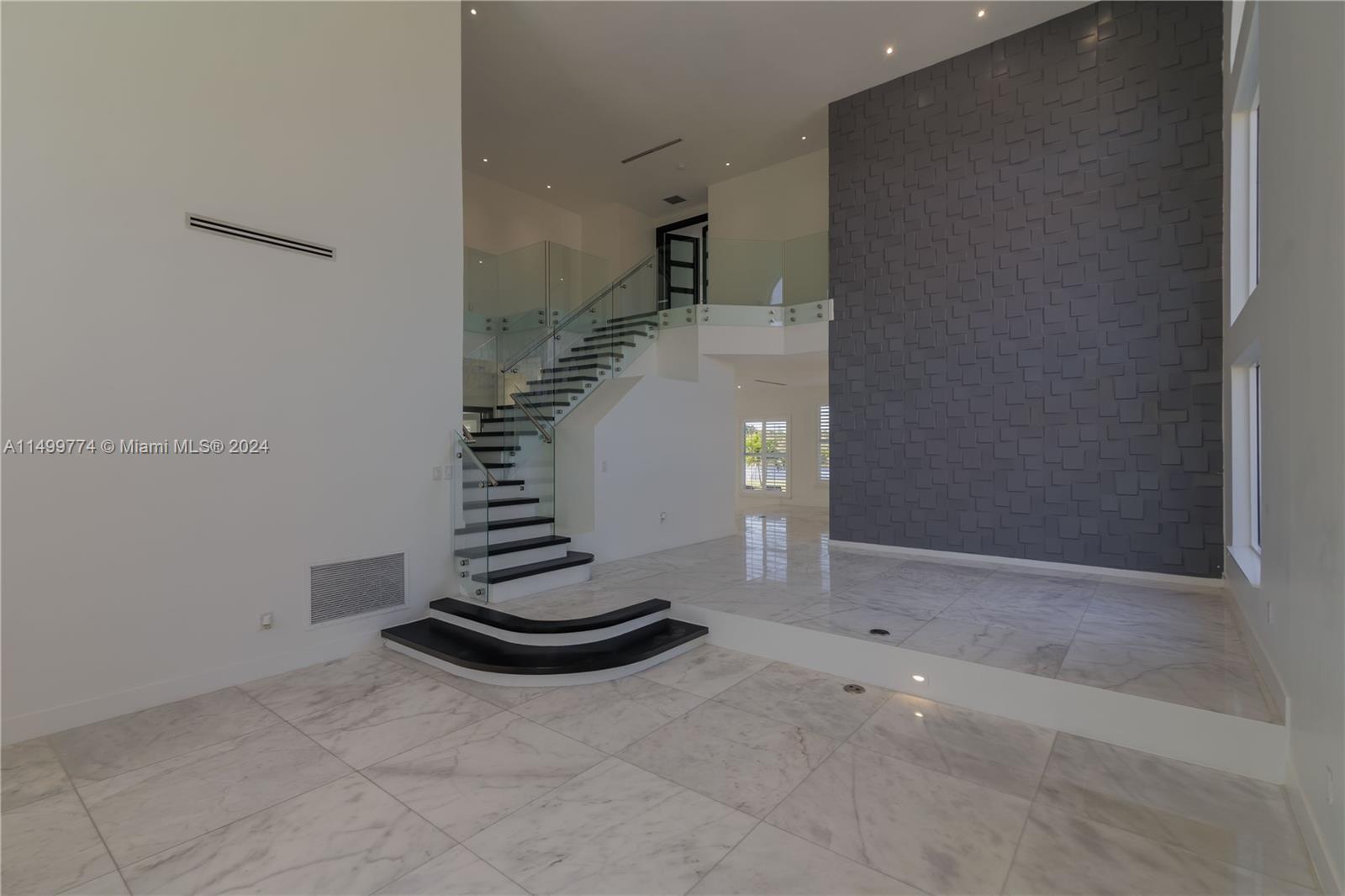 The wooden and glass staircase in this house is a masterpiece of modern design. The wooden steps, crafted with precision, add a touch of warmth and natural beauty to the space, while the glass balustrade provides a contemporary and airy feel.