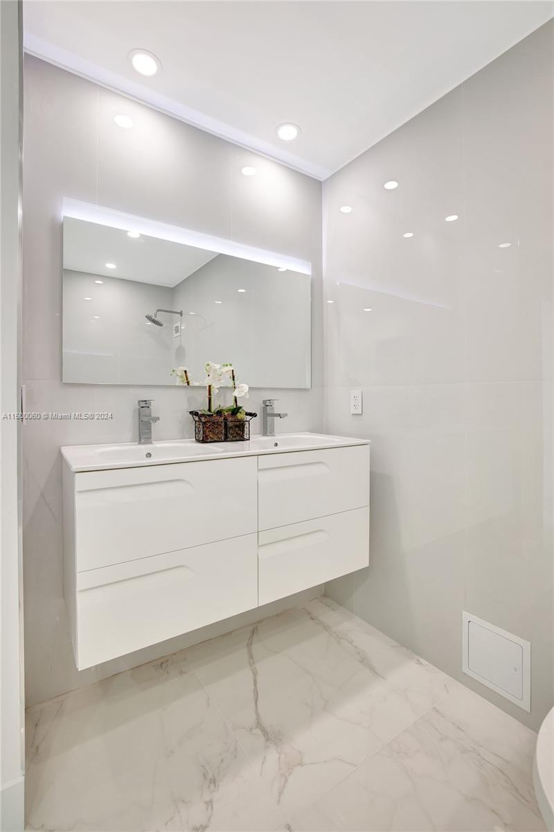 PRINCIPLE BEDROOM SUITE OFFERS CUSTOM FITTED CLOSET SYSTEMS, HIGH VOLUME 9 FT CEILINGS , PRIVATE WASHER & DRYER , SPA STYLE CUSTOM DESIGNED BATHROOM & WIDE WALL TO WALL HURRICANE IMPACT WINDOW COASTLINE OCEAN VIEWS