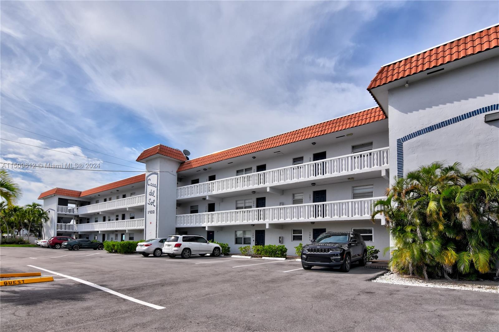3 story building with elevator and several guest parking spaces.