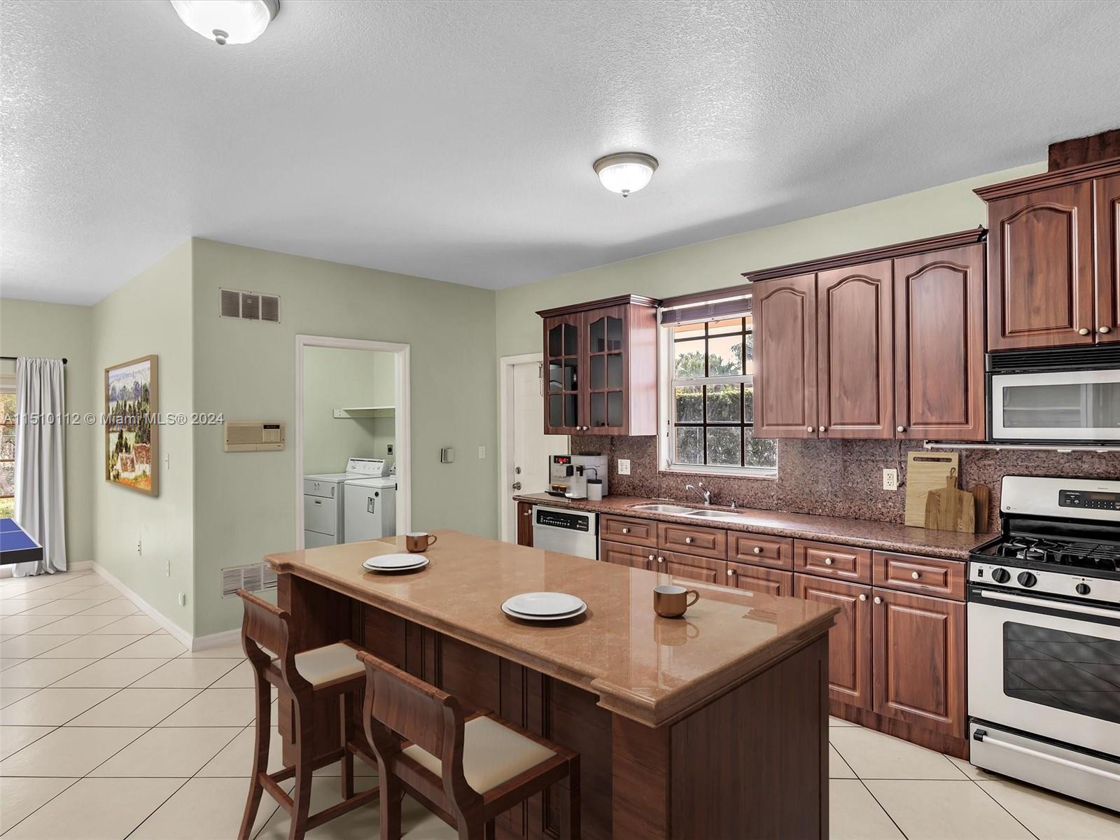 Ample kitchen, with granite counters, gas range, and large pantry. Virtually Staged Photo.