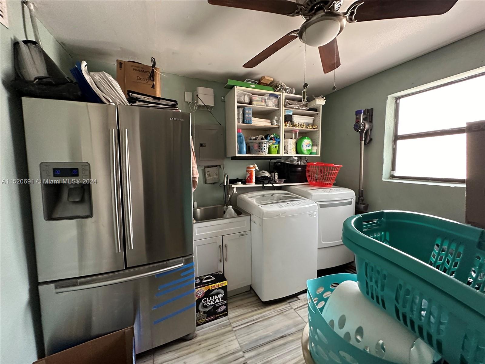 Laundry room with another refrigerator.