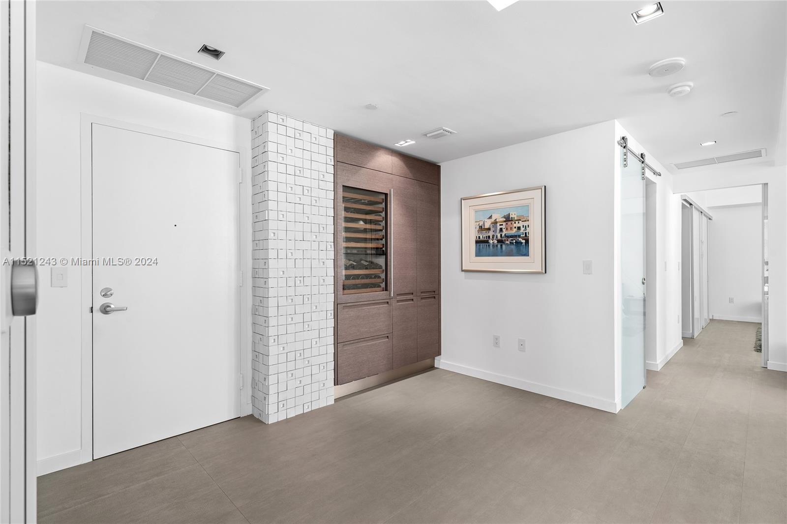 Entry foyer to Residence with Sub-Zero 30-in Wine Cellar with refrigeration storage.