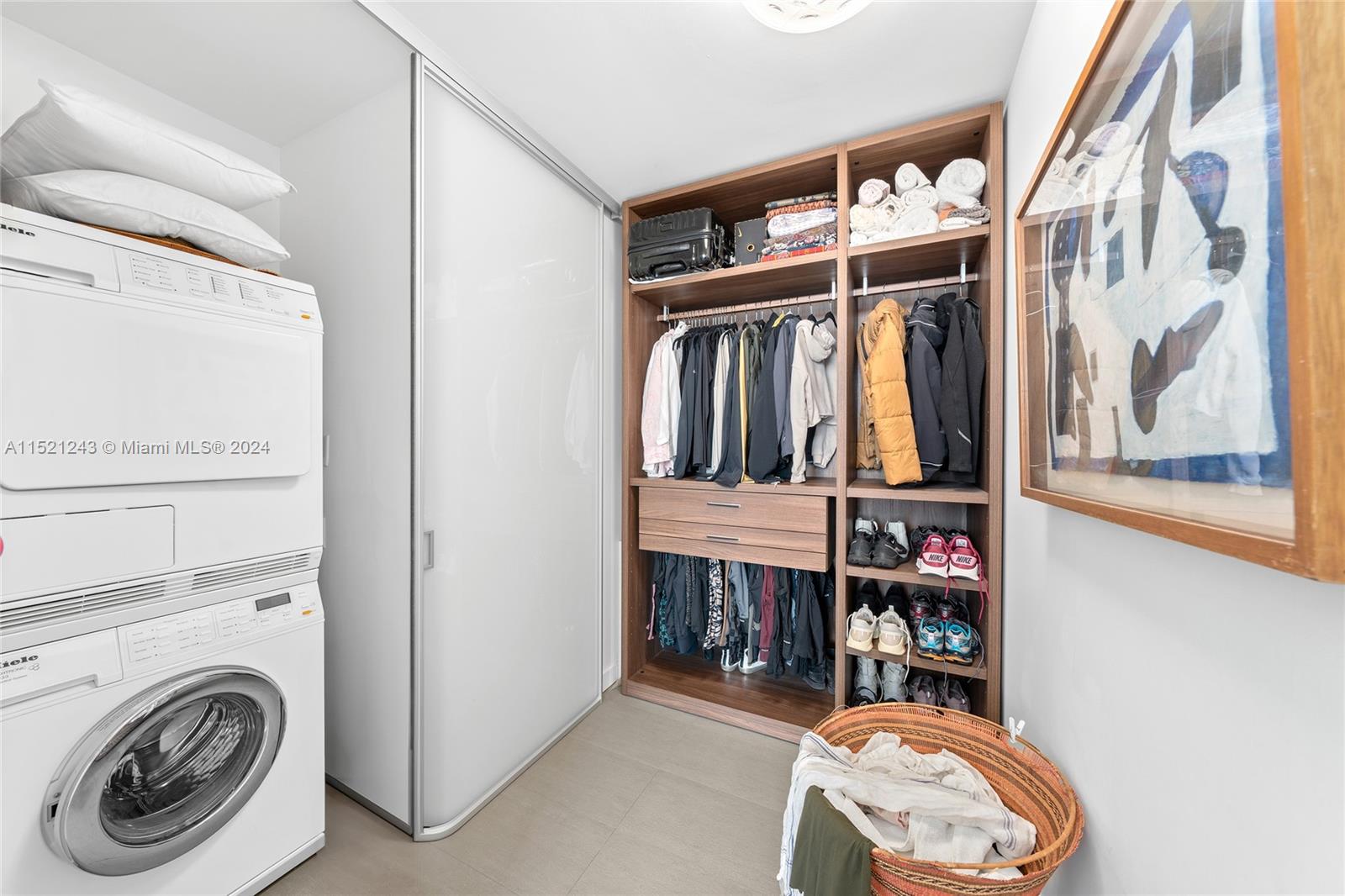 Walk in closet with Miele Washer & Dryer.  Floating/sliding doors added for space optimization.