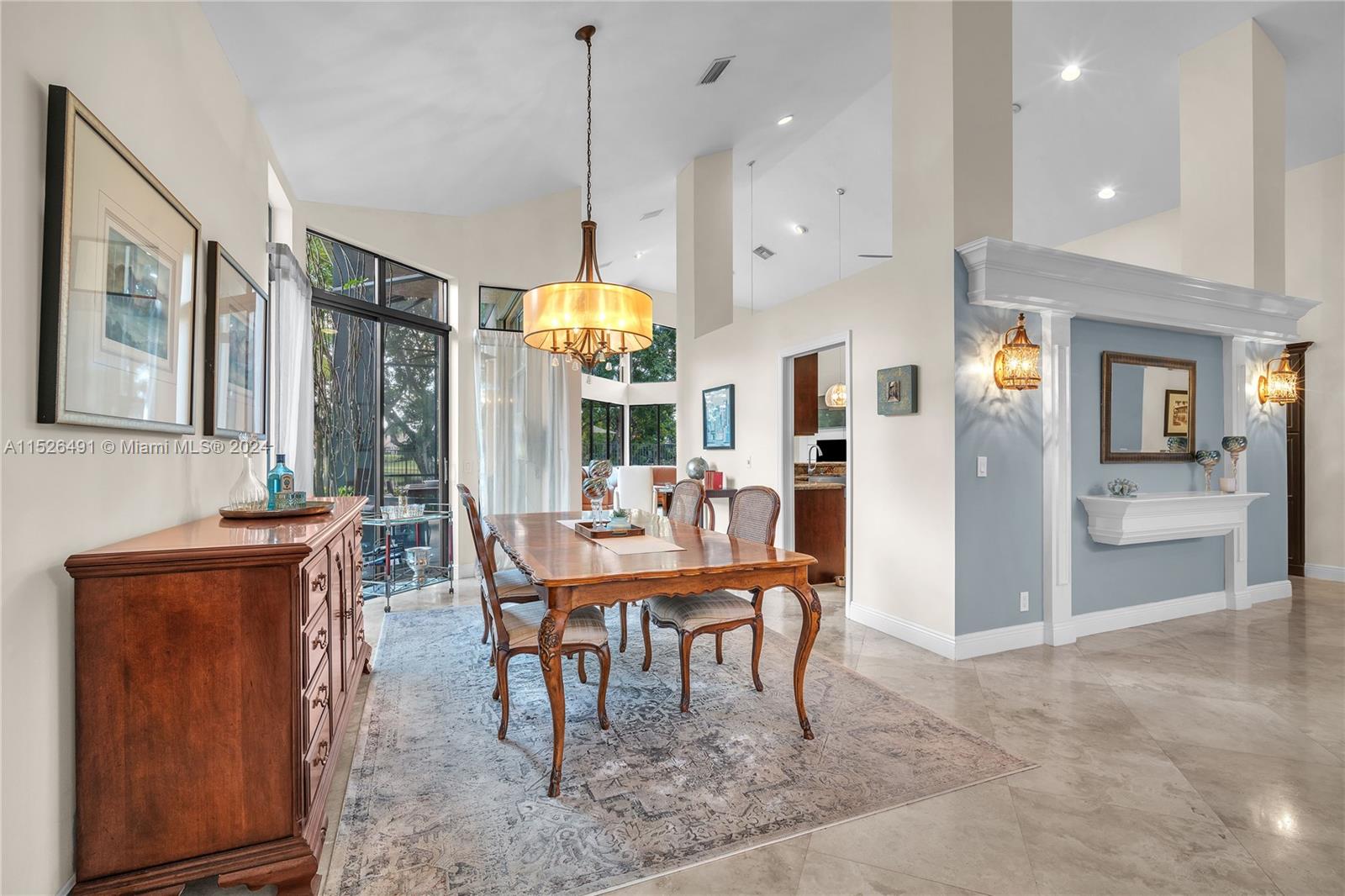 Formal dining room with entry into the kitchen overlooking patio.