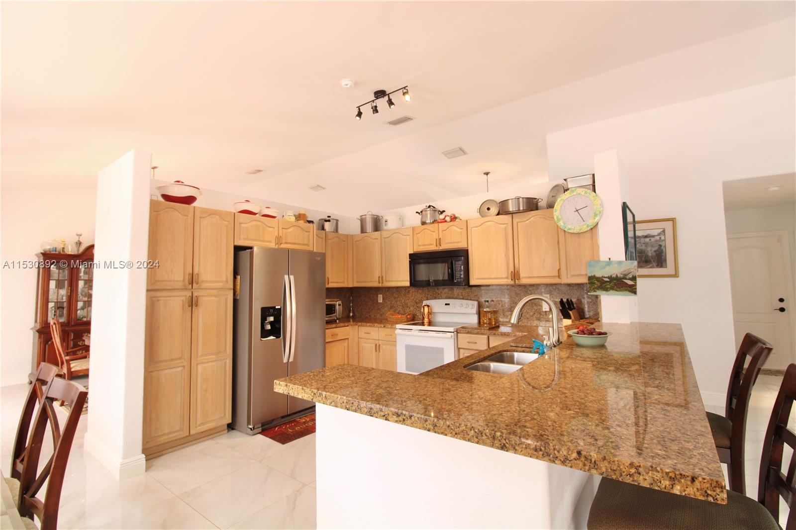 Granite counters, wood cabinets, snack bar.