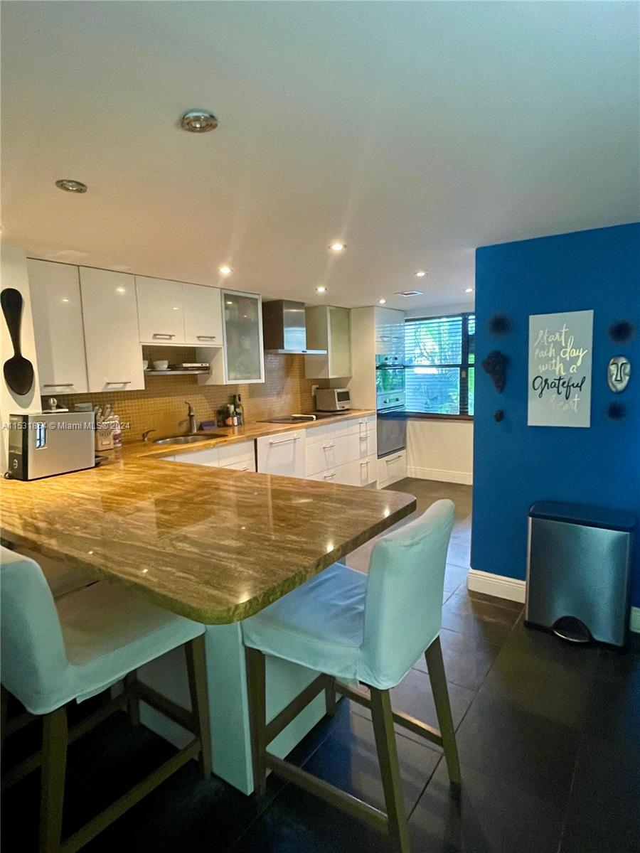 Renovated open kitchen with a large granite bar.