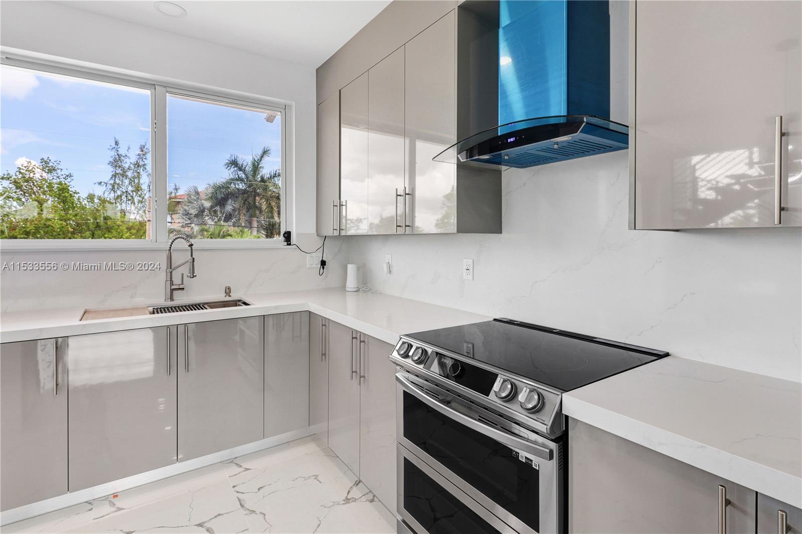 Dual convection ovens, quartz counters, vented range hood, and custom cabinetry
