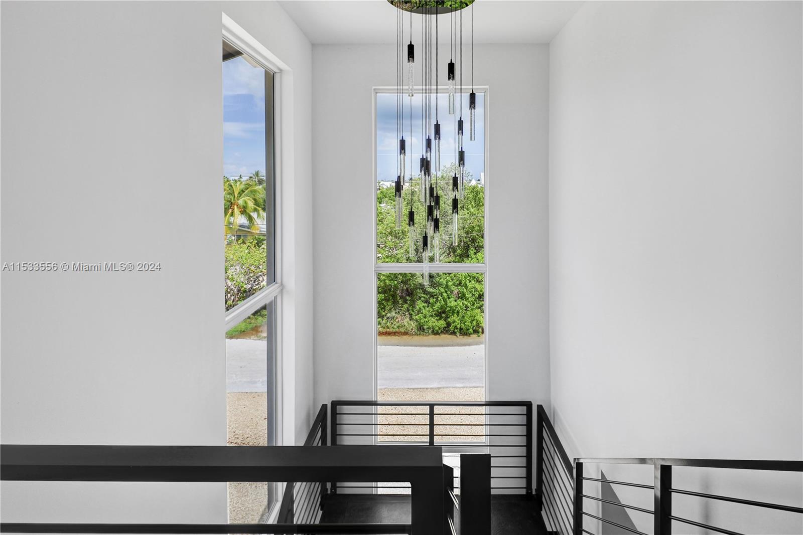 Open stairwell to the 2nd floor with custom slate stairs and LED chandelier