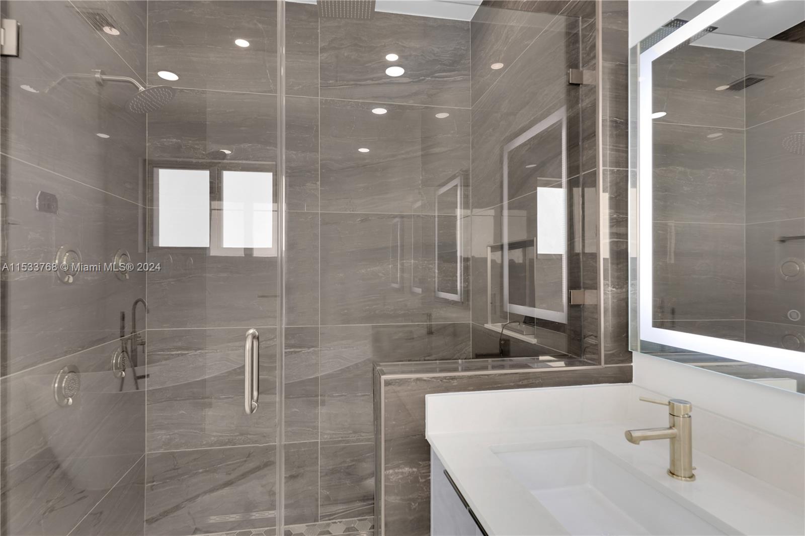 Stand alone tub, dual LED lighted vanity and custom shower with MOEN programmable controls