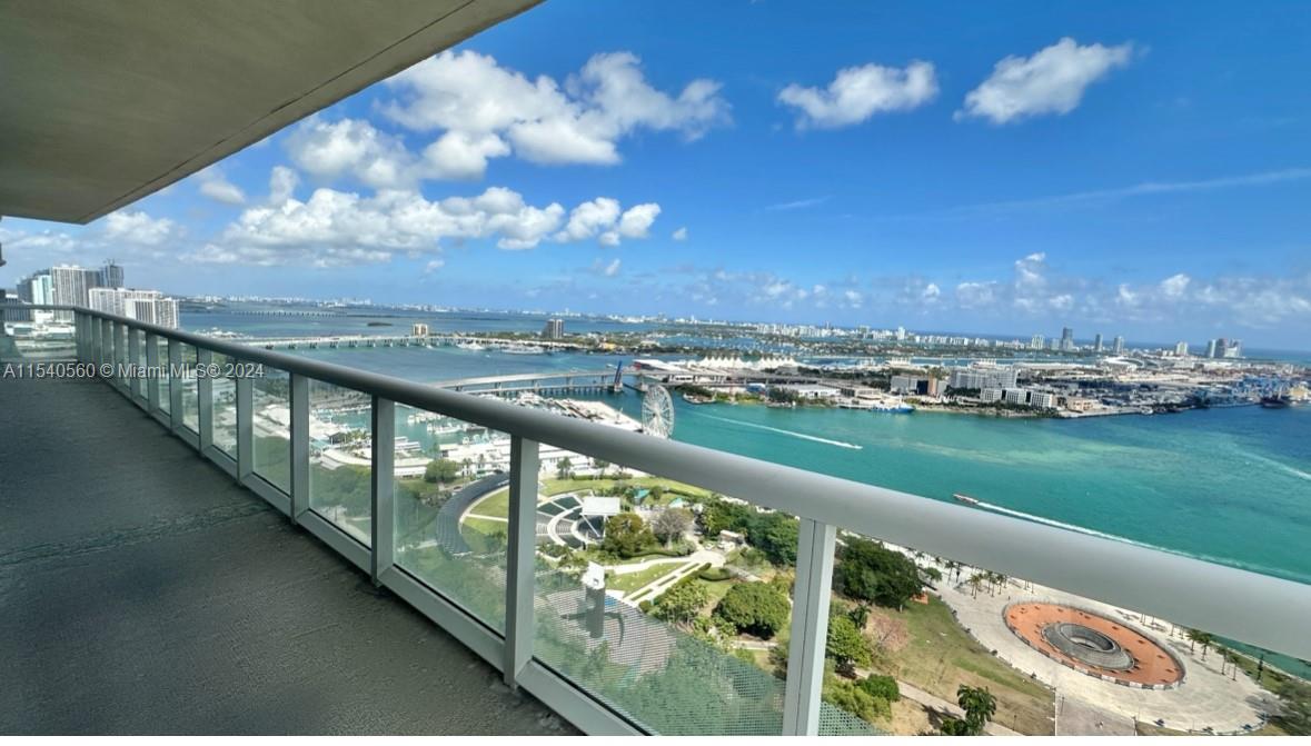 Step into luxury living at this 3-bed, 2-bath condo in downtown Miami's iconic 50 Biscayne. With wood floors, floor-to-ceiling windows, and direct water views, this corner unit offers the best of city living. The master suite features double sinks, a shower, a separate tub, and two walk-in closets, with access to a spacious balcony. Entertaining guests is effortless in the generously sized living area that seamlessly flows onto the nearly 400 sqft wrap-around balcony overlooking the bay, creating an idyllic setting for gatherings, or simply unwinding after a long day. Residents also benefit from top-tier amenities including a spa, pool, gym, and 24/7 concierge. With a prime location near dining, shopping, and entertainment, this condo offers a stylish urban lifestyle in the heart of Miami