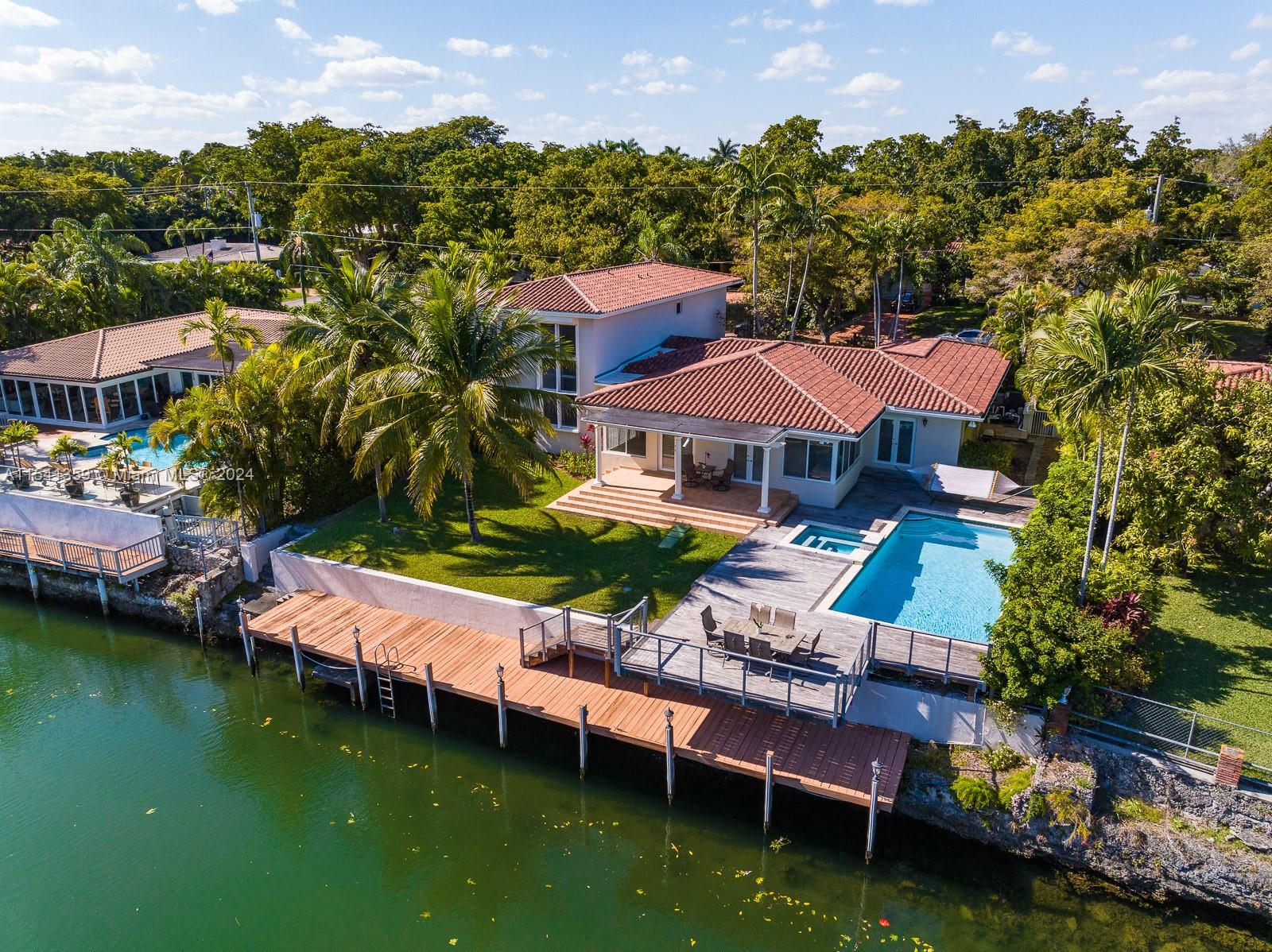 Welcome to 616 Jeronimo, a truly exquisite waterfront residence nestled on a quiet picturesque Coral Gables street. This tasteful home offers an elegant retreat w/5 bedrooms encompassing 3764sf. Upon entering the home, you are greeted by a panoramic water vista, beckoning you outside. The 1st floor boasts the primary bedroom plus 2 others, while the 2nd floor unveils a suite including a second family room, wet bar, & 2 spacious bedrooms. In addition, there is a large, 1st floor flex-bonus room. Love the outdoors? There is a 70’ boat dock as well as a pool with a cantilevered Ipe wood deck overhanging the water. This residence offers the epitome of Coral Gables living, w/a harmonious blend of luxury, privacy, & convenience. Make this spacious, waterfront home your own: A Very Special Home.