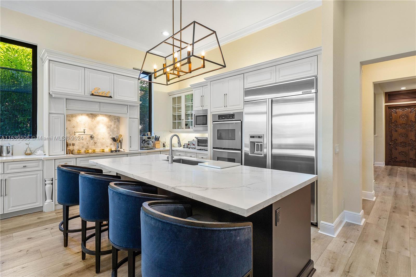 Kitchen view with quarts countertops and high end appliances /hallway leading to second floor/ laundry room at the end of corridor