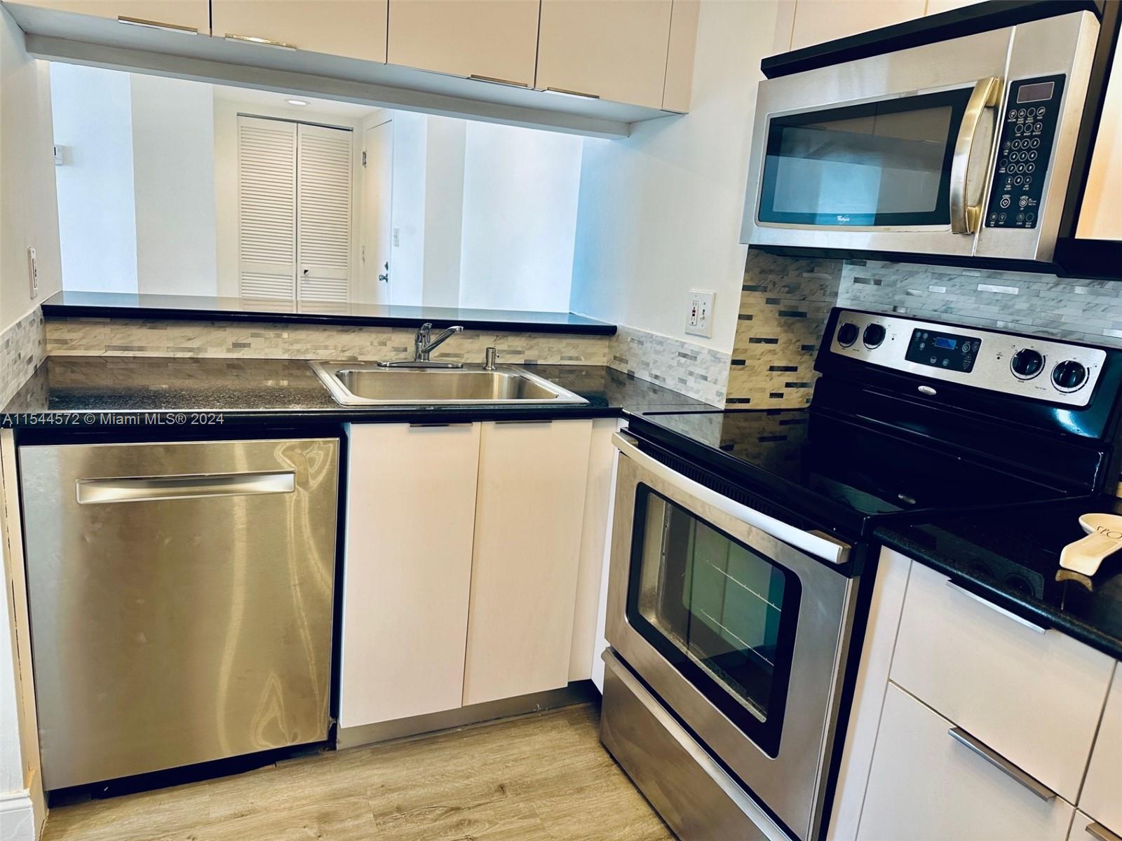 KITCHEN WITH STAINLESS STEEL APPLIANCES.