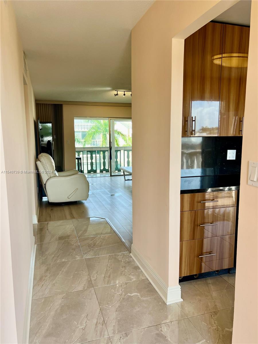 Entry foyer and kitchen both feature beautiful modern oversized large tile.
Entry foyer has storage closet.