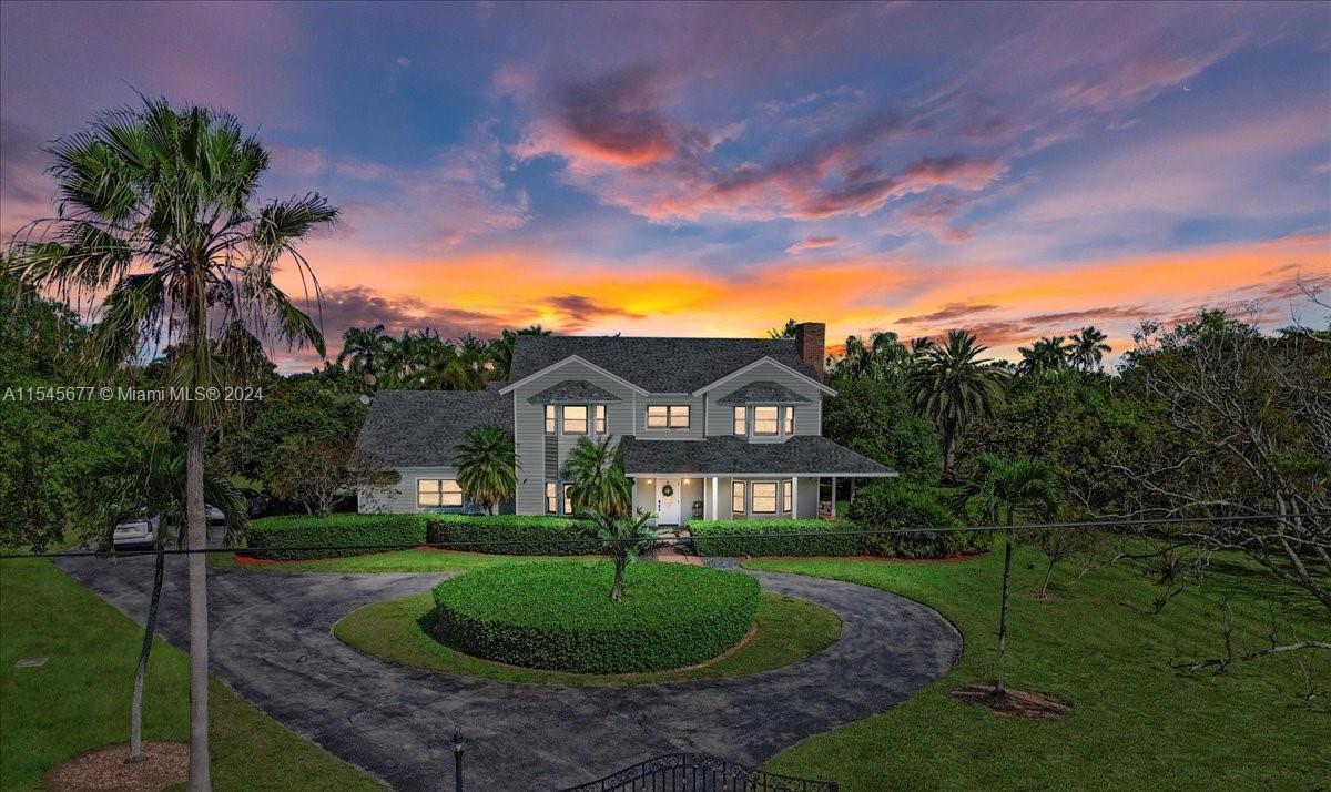 This graceful 2-story Southern Living Colonial-inspired home offers a private haven on a lush 2.5-acre estate in The Redland. The symmetrical facade is complemented by a wraparound porch and circular driveway. Inside, 3 bedrooms, including an owners suite w/ a Jacuzzi and walk-in closet, offer a comfortable retreat. Oak flooring, dual fireplaces in the office & family room, & a spacious kitchen suited for gatherings define the interior. Outside, the quintessential South Florida experience is captured w/a spacious 50x20 pool designed for laps & leisure, surrounded by a diverse collection of fruit trees.The property includes horse stalls, a tack room, over-sized garage, electric gate, newer roof & a 55KW generator that powers the entire home, ensuring a blend of rural charm and convenience.