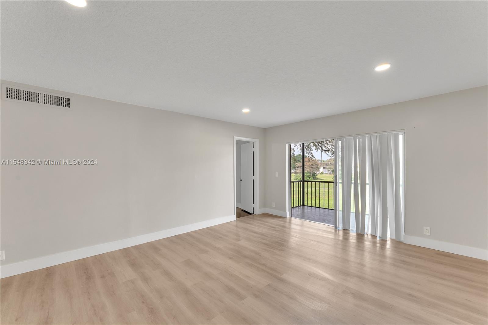 Living Room w/Glimpse of Bedroom 2 Door and Patio