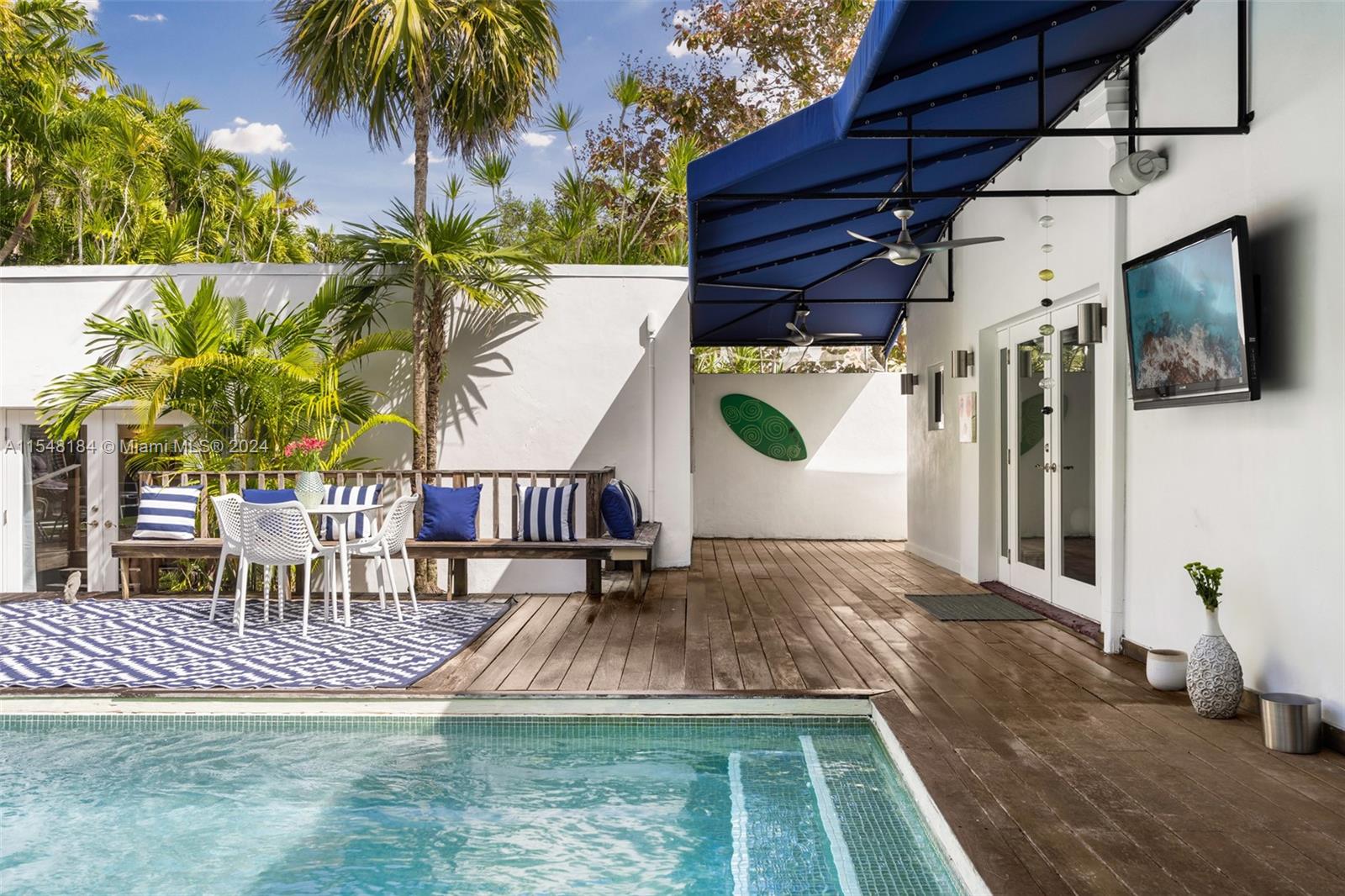 Newly tiled pool landscaped with palm and bamboo trees.