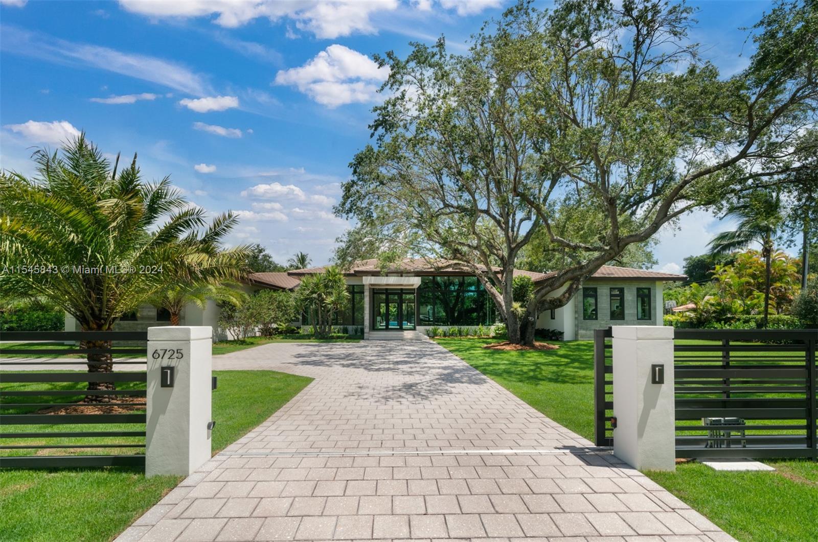 In the heart of North Pinecrest, this exceptional single-story residence. Just completed summer 2024., on a large 175' wide x 223' deep lot. Premium finishes adorn every corner. The kitchen and dining room blend seamlessly, boasting sleek lines and ample space for culinary adventures. The living space exudes warmth, enhanced by floor-to-ceiling impact glass windows showcasing breathtaking panoramic views. Adding to the allure of luxury living, a detached guest house connected by a covered breezeway complements the main dwelling. Outside, a lush tropical sanctuary awaits with covered terraces, a heated pool, and a fully equipped summer kitchen. Gated access, media room, gym, full house generator and a three-car garage provide added convenience. Elite Pinecrest Schools nearby.