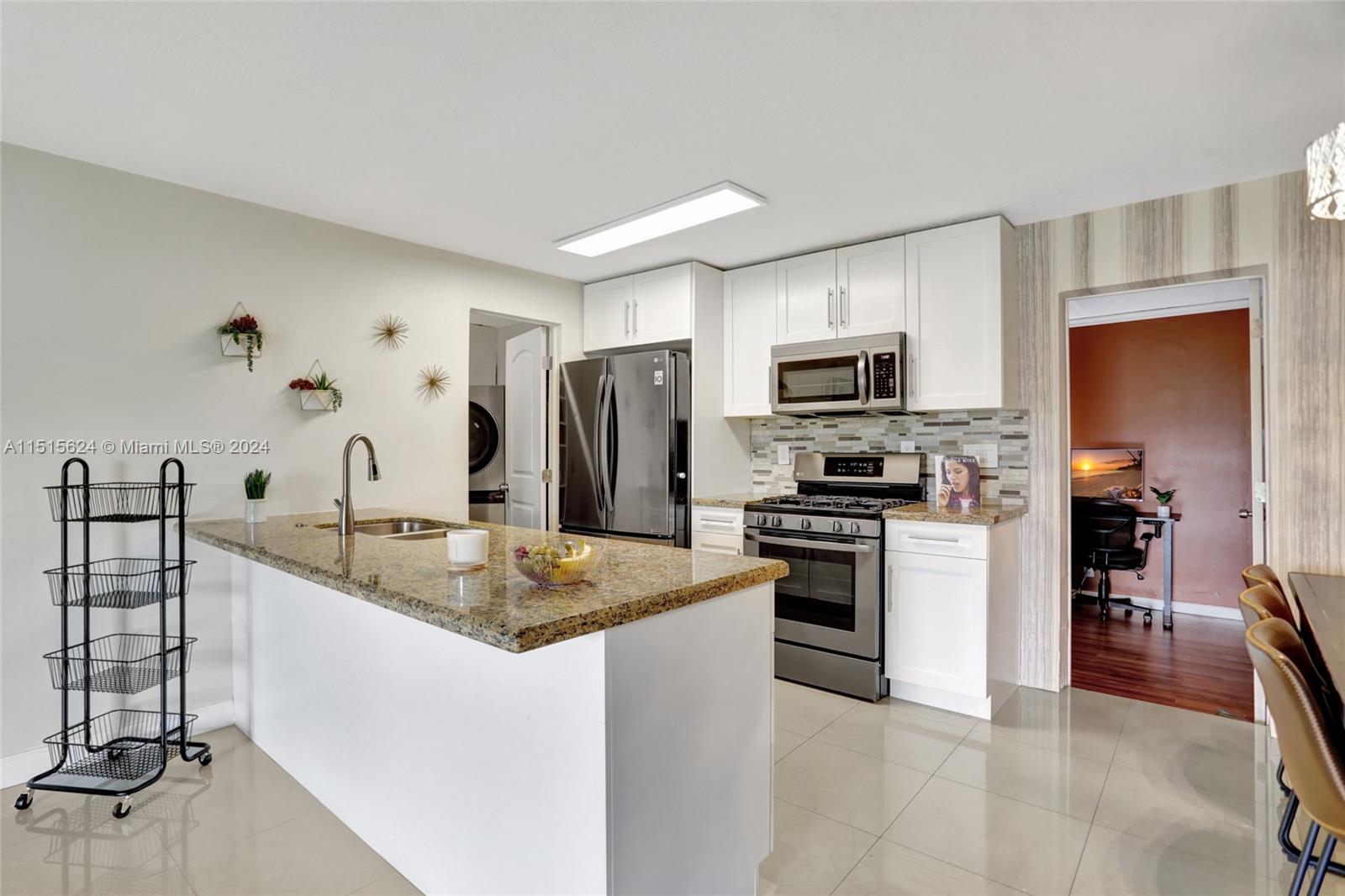 Updated kitchen with granite counters, stainless steel appliances, white Shaker style cabinets and gas stove.