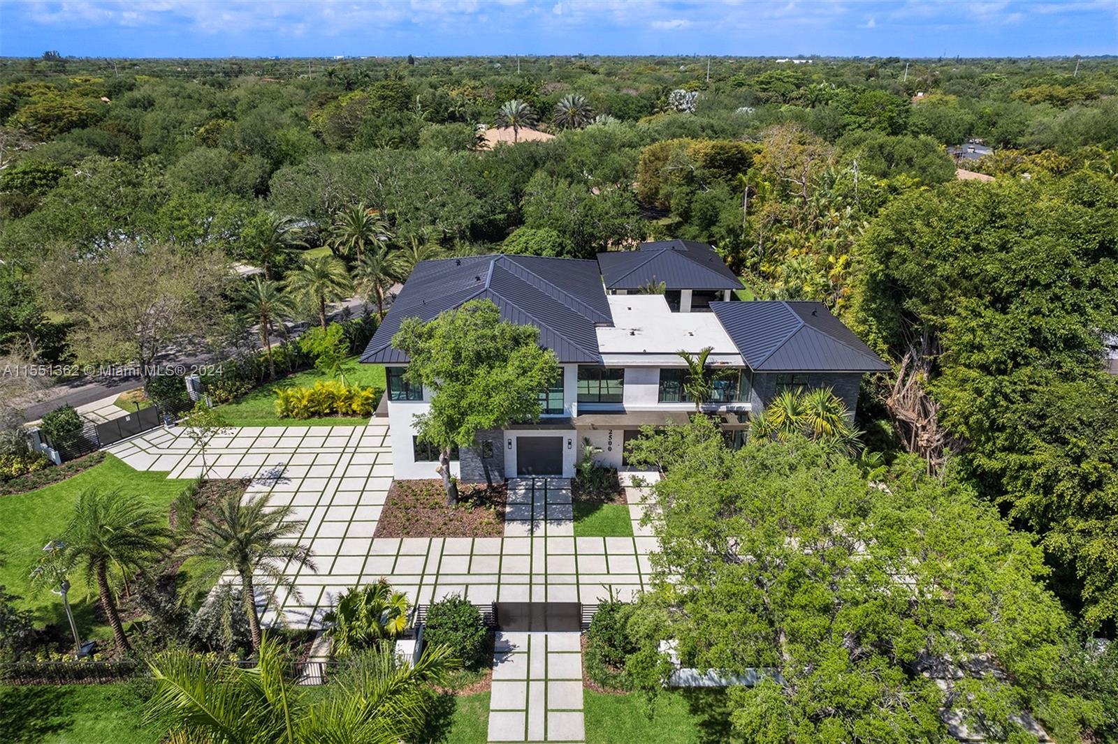 Indulge in the opulence of this immaculate 2024 brand-new modern estate in Pinecrest, meticulously crafted w/ exquisite finishes & unparalleled attention to detail. Enter the tropical oasis, where 23ft ceilings & dramatic linen draperies set the stage. This home captivates w/ dual kitchens, ideal for chef’s & homeowner’s culinary skills w/ Italian cabinetry, Subzero/Wolf appl, unique capsule elevator & entertainer's family rm. The ground flr reveals a hidden guest suite & service quarters, while the 2nd flr hosts 3 bedrm’s & a lavish master suite w/ sitting area, spa-like bath & terrace. The outdr retreat boasts a 1br/2ba guest house w/ family rm, summer kitchen, terrace & captivating pool/spa. Equipped w/ designer lighting, custom wood paneling, smart home integration, & 3-car gar.