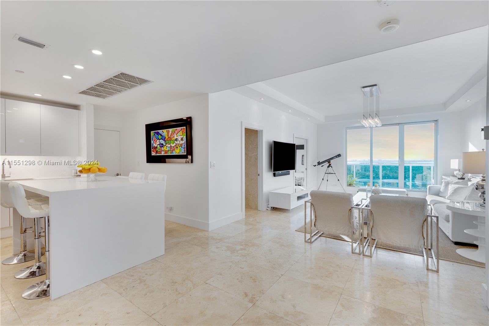Step into this stunning living room and be greeted by a breathtaking view of the iconic Miami skyline. The floor-to-ceiling windows, complemented by the 10 ft ceilings, flood the apartment with an abundance of natural light, creating a spacious and airy atmosphere. The modern design and open layout make this the perfect space for both relaxation and entertaining, with the vibrant cityscape serving as the ultimate backdrop.