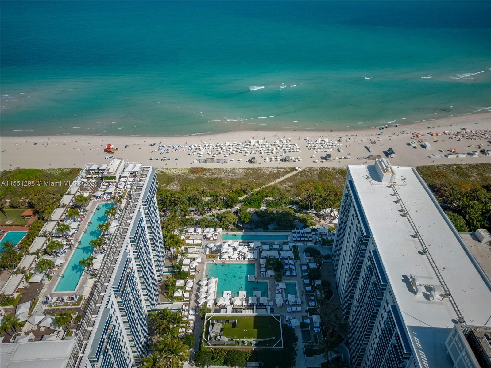 Take in the stunning view of the coast from high above! This amazing photo shows the beautiful beachfront that's just waiting to be enjoyed. And that's not all – the property also gives you access to a fantastic hotel pool, perfect for relaxing and having fun. It's like being on vacation every day. Welcome to your own piece of paradise