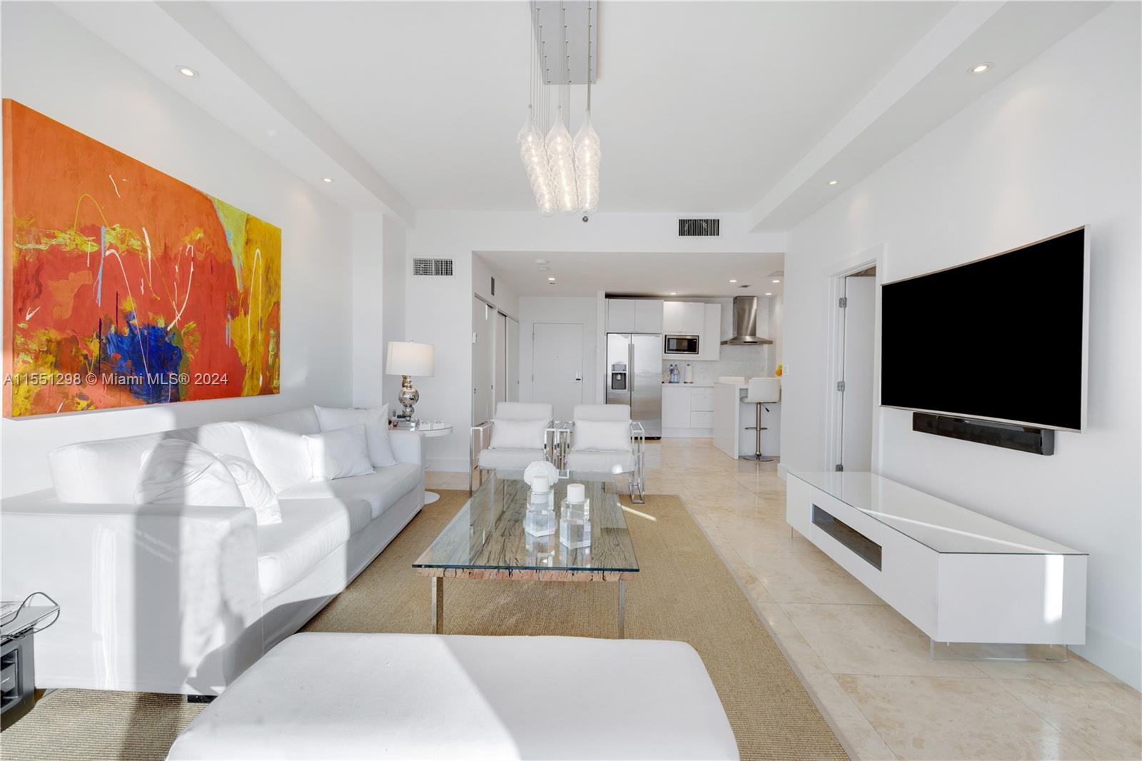 Step into this stunning living room and be greeted by a breathtaking view of the iconic Miami skyline. The floor-to-ceiling windows, complemented by the 10 ft ceilings, flood the apartment with an abundance of natural light, creating a spacious and airy atmosphere. The modern design and open layout make this the perfect space for both relaxation and entertaining, with the vibrant cityscape serving as the ultimate backdrop.